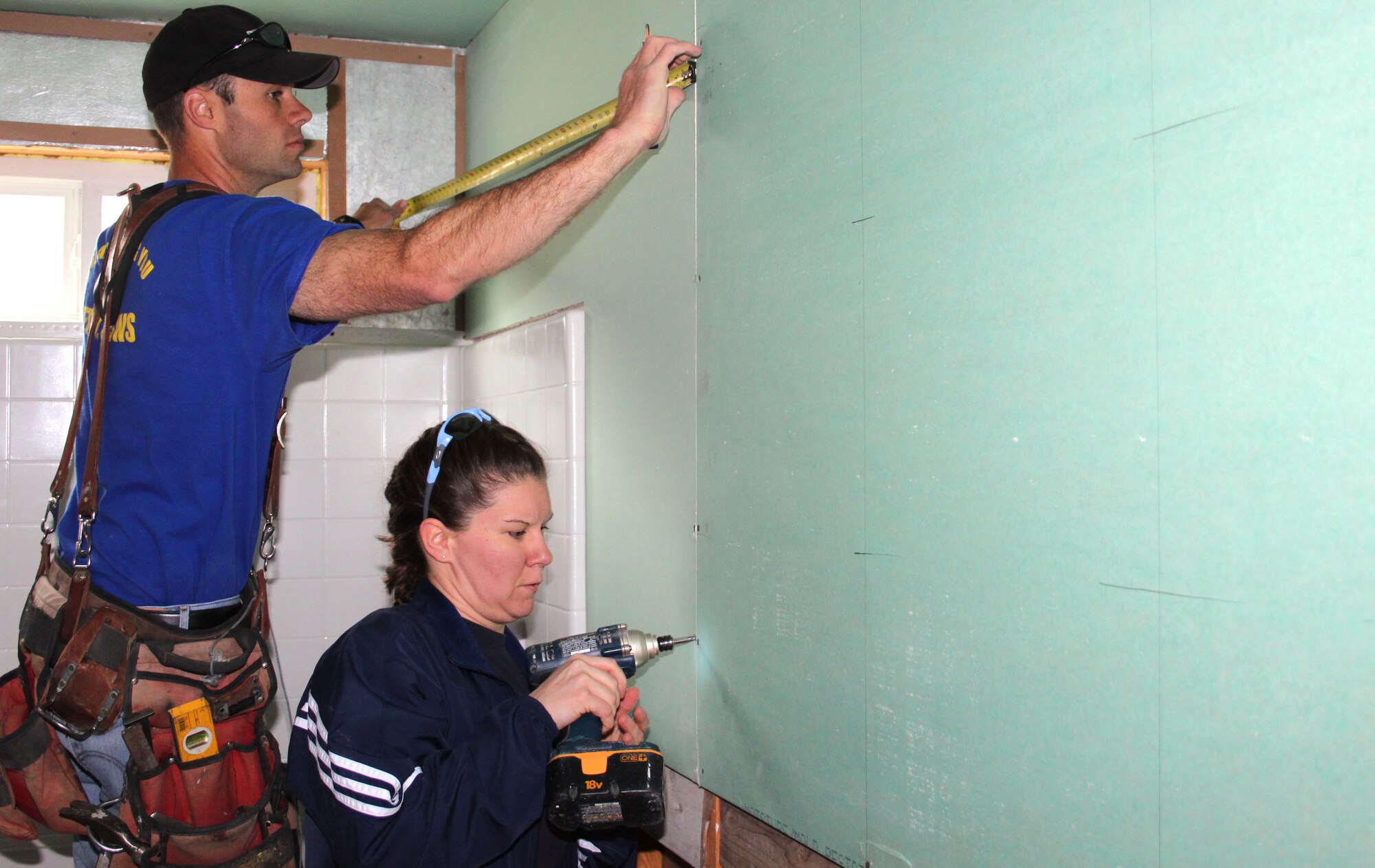 Senior Airman Nolden Soerensen, Det. 1 8 SWS, and Tech. Sgt. Kasey L. Grindrod (right), 310th SW Equal Opportunity and Yellow Ribbon, measure and hang drywall while volunteering with the 310th Space Wing Junior Enlisted Council for the Pikes Peak Habitat for Humanity on April 7. The 310 JEC teamed up with the 50th Space Wing 5/6 Council to assist in building a local home for a family in need. (U.S. Air Force photo by Tech. Sgt. Scott P. Farley)