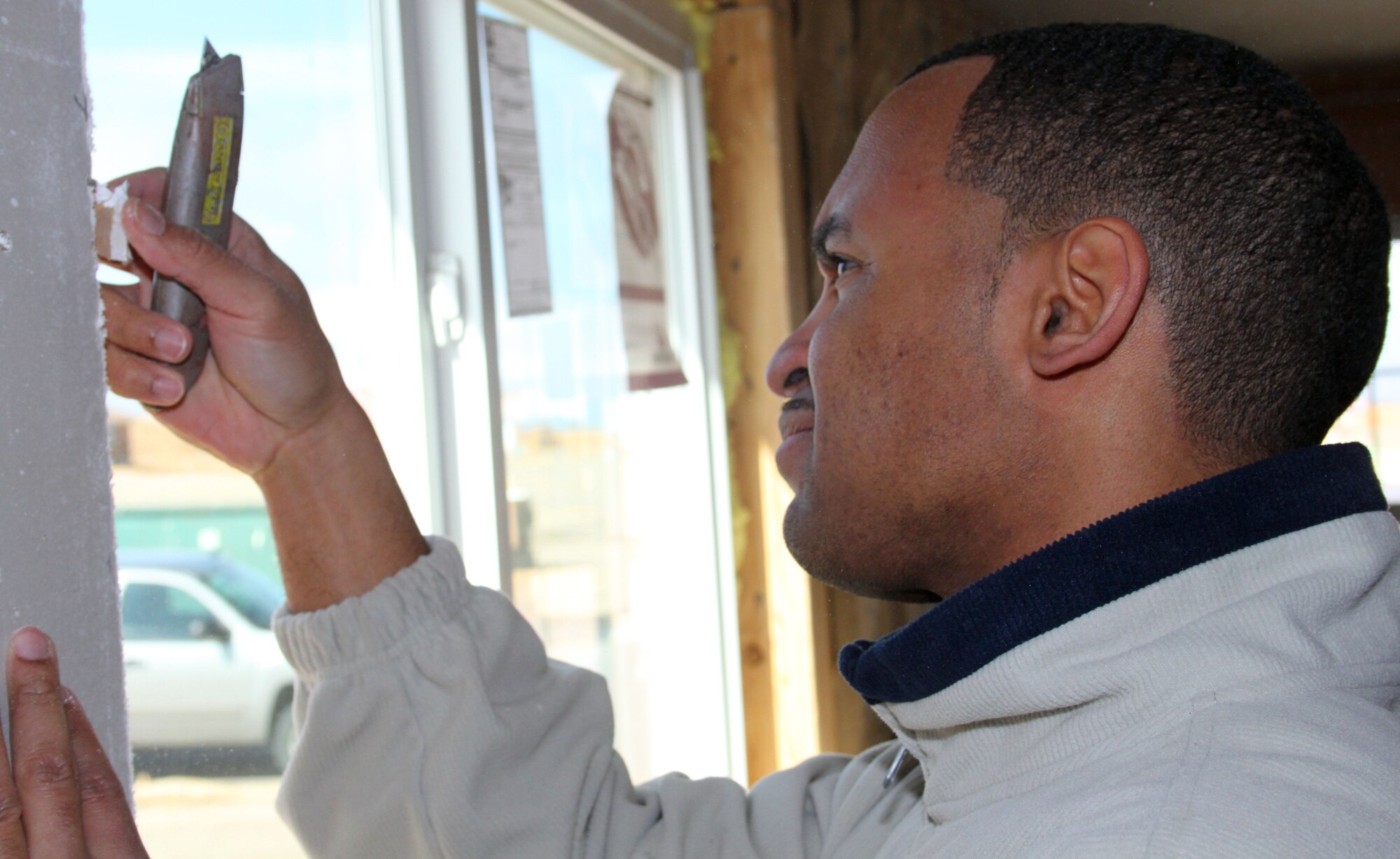 Tech. Sgt. Germaine Miller, 380th Space Control Squadron, trims drywall while volunteering with the 310th Space Wing Junior Enlisted Council for the Pikes Peak Habitat for Humanity on April 7. The 310 JEC teamed up with the 50th Space Wing 5/6 Council to assist in building a local home for a family in need. (U.S. Air Force photo by Tech. Sgt. Scott P. Farley)