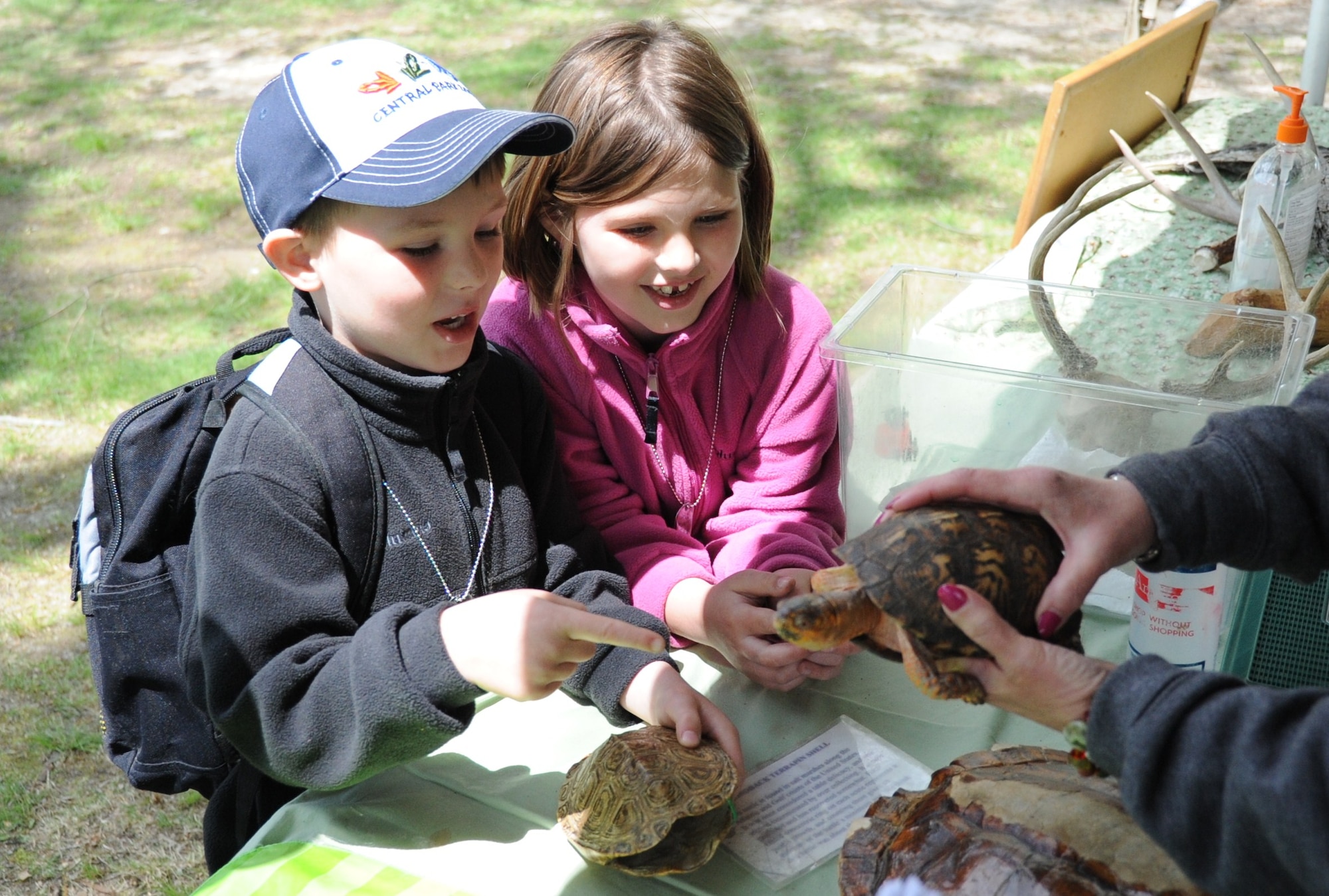 Katie, 7, and Jonah, 5, children of Capt. Heather Wingard, North East Army Reserve Intelligence Support Center, get a chance to touch and play with a turtle during the Joint Base McGuire-Dix-Lakehurst Earth Day festivities Saturday at Laurel Pond. Many exhibits and static displays from local nature centers and parks were on display to educate the joint base community. (U.S. Air Force photo by Airman 1st Class Bryan Swink/Released)