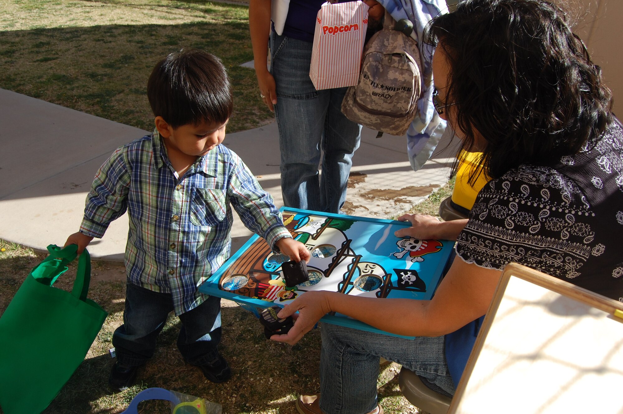 Brady Garcia drops a beanbag into a slot on the pirate ship board game.