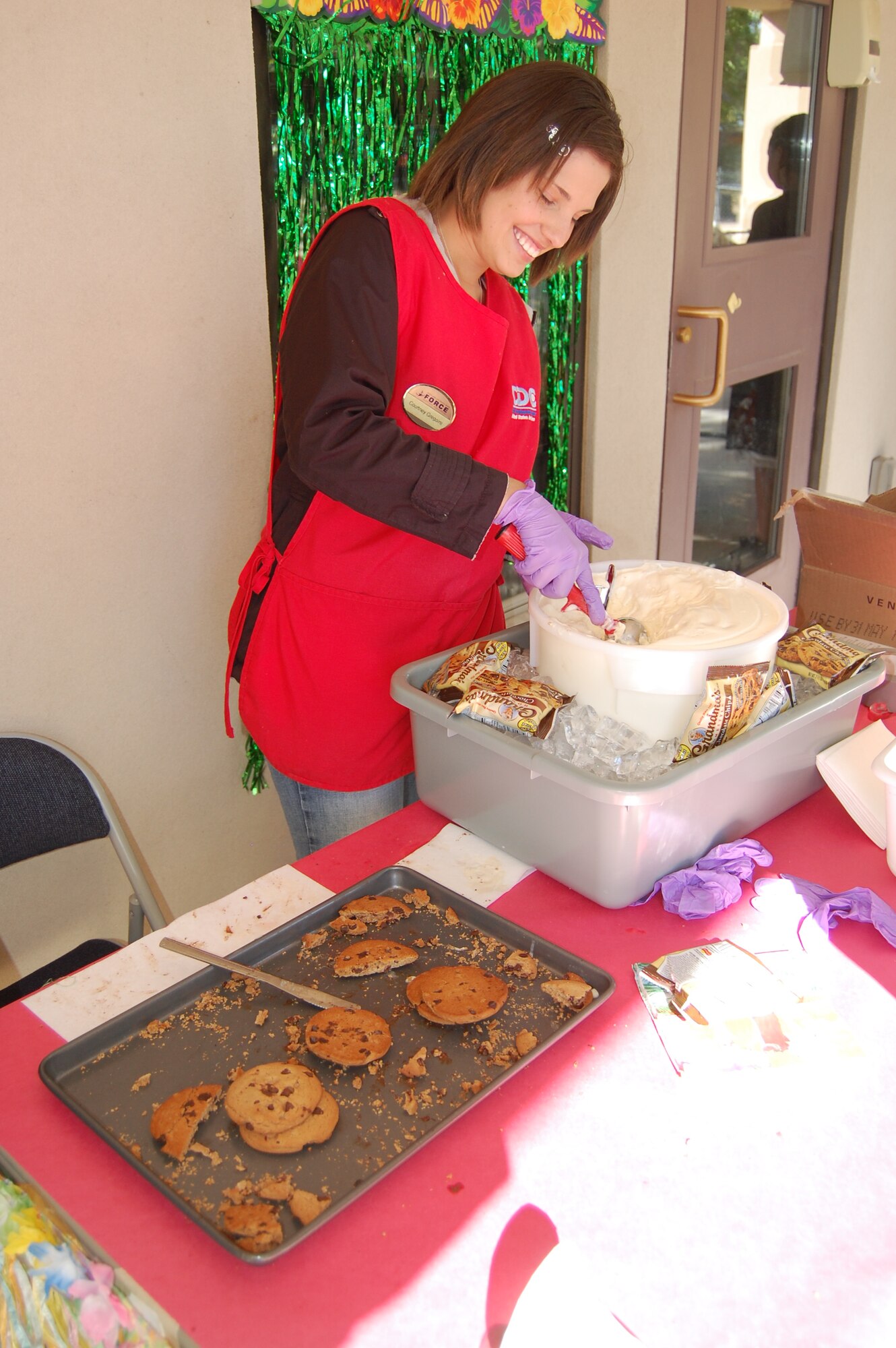 Courtney Gregoire makes ice cream sandwiches for children at the carnival.