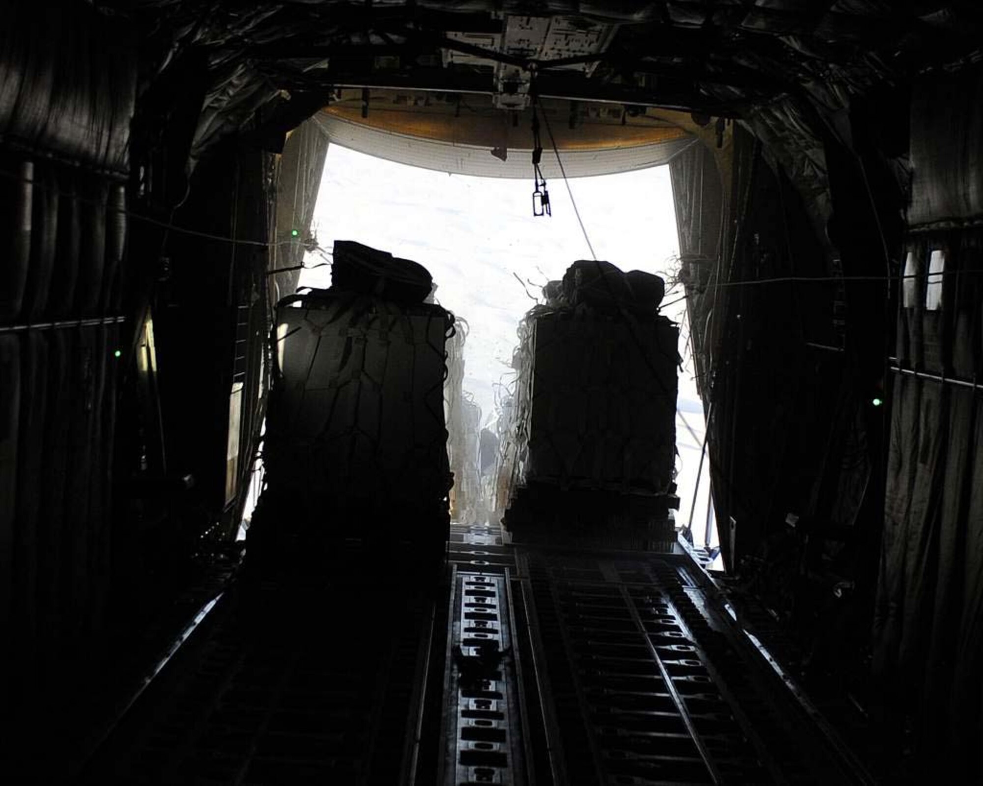 The payload from a C-130J Super Hercules airdrop mission exits the aircraft May 6, 2011, in Afghanistan. When supplies are delivered by airdrop, lives may potentially be saved by avoiding roadside attacks that are more common in Afghanistan.  The C-130J is assigned to the 772nd Expeditionary Airlift Squadron, 451st Air Expeditionary Wing. (U.S. Air Force photo by Senior Airman Willard E. Grande II)