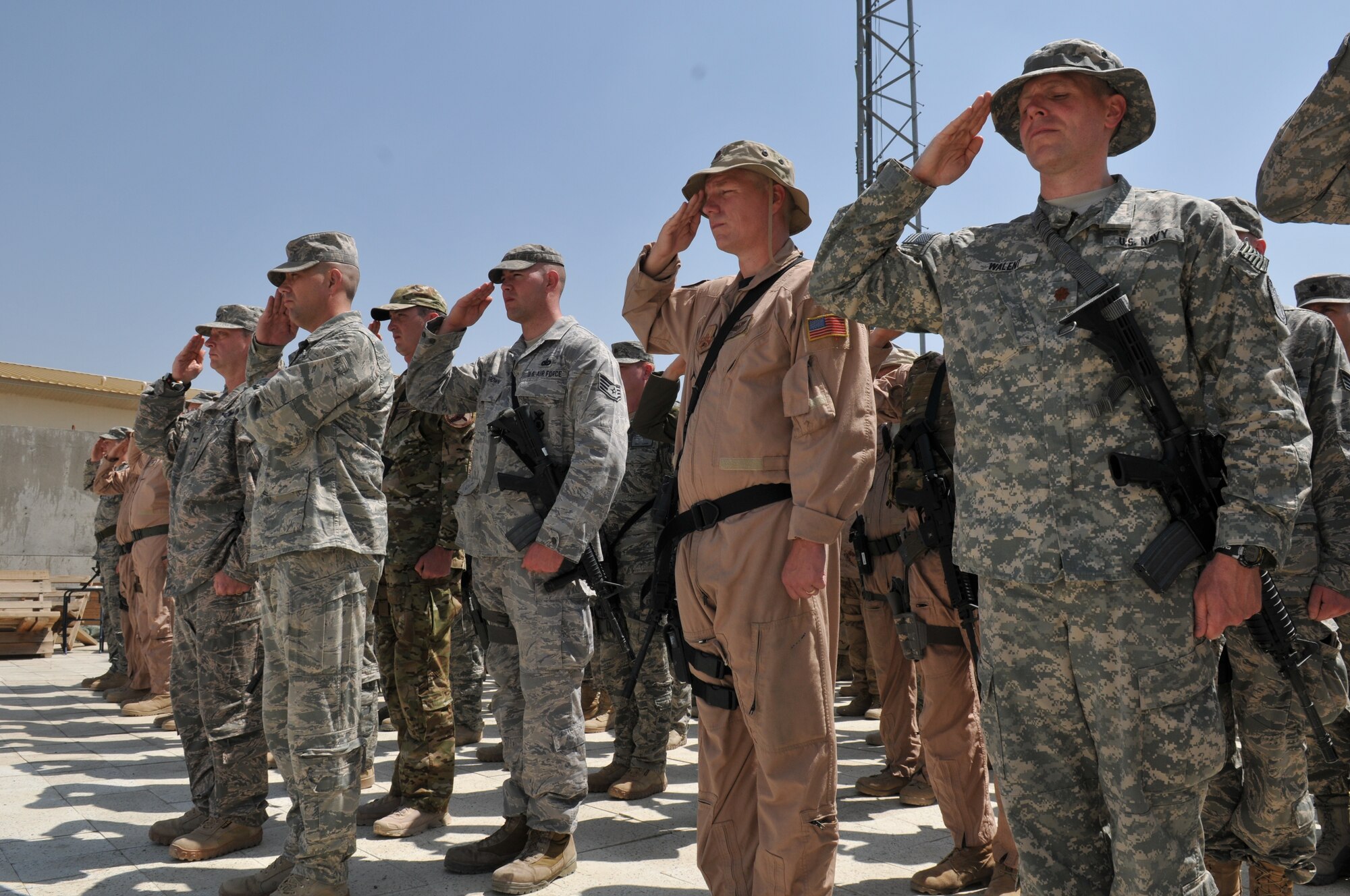 KABUL, Afghanistan -- U.S. and NATO coalition forces salute the American flag during a flag-raising ceremony at the 438th Air Expeditionary Wing May 6. The ceremony marked nine days to the hour when eight Airmen and one retired Army civilian contractor were killed when a gunman opened fire during a meeting with NATO trainers.  (U.S. Air Force photo by Tech. Sgt. Brian E. Christiansen)