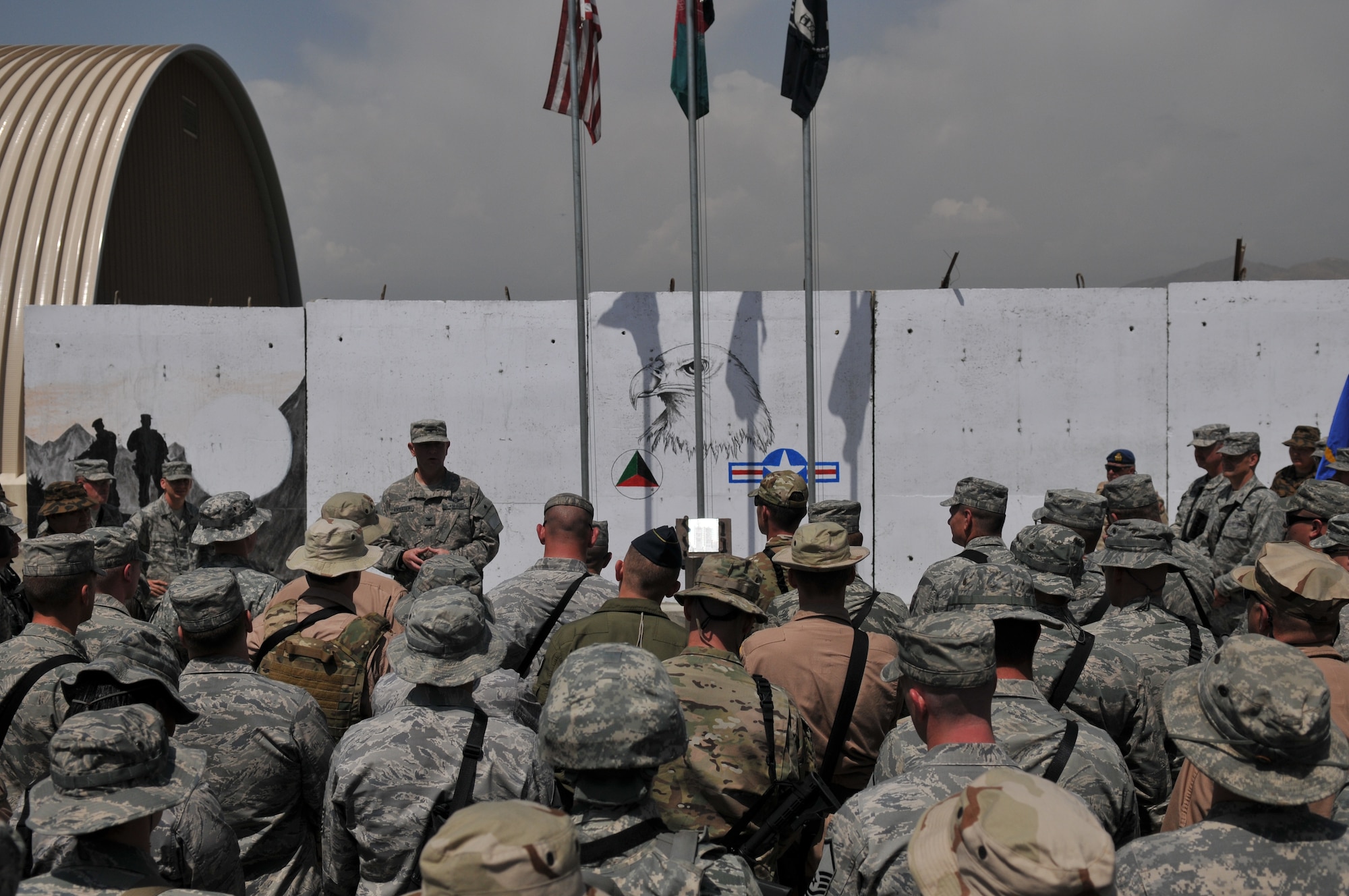 KABUL, Afghanistan -- U.S. and NATO coalition forces stand in formation during a flag-raising ceremony at the 438th Air Expeditionary Wing May 6. The ceremony marked nine days to the hour when eight Airmen and one retired Army civilian contractor were killed when a gunman opened fire during a meeting with NATO trainers.  (U.S. Air Force photo by Tech. Sgt. Brian E. Christiansen)