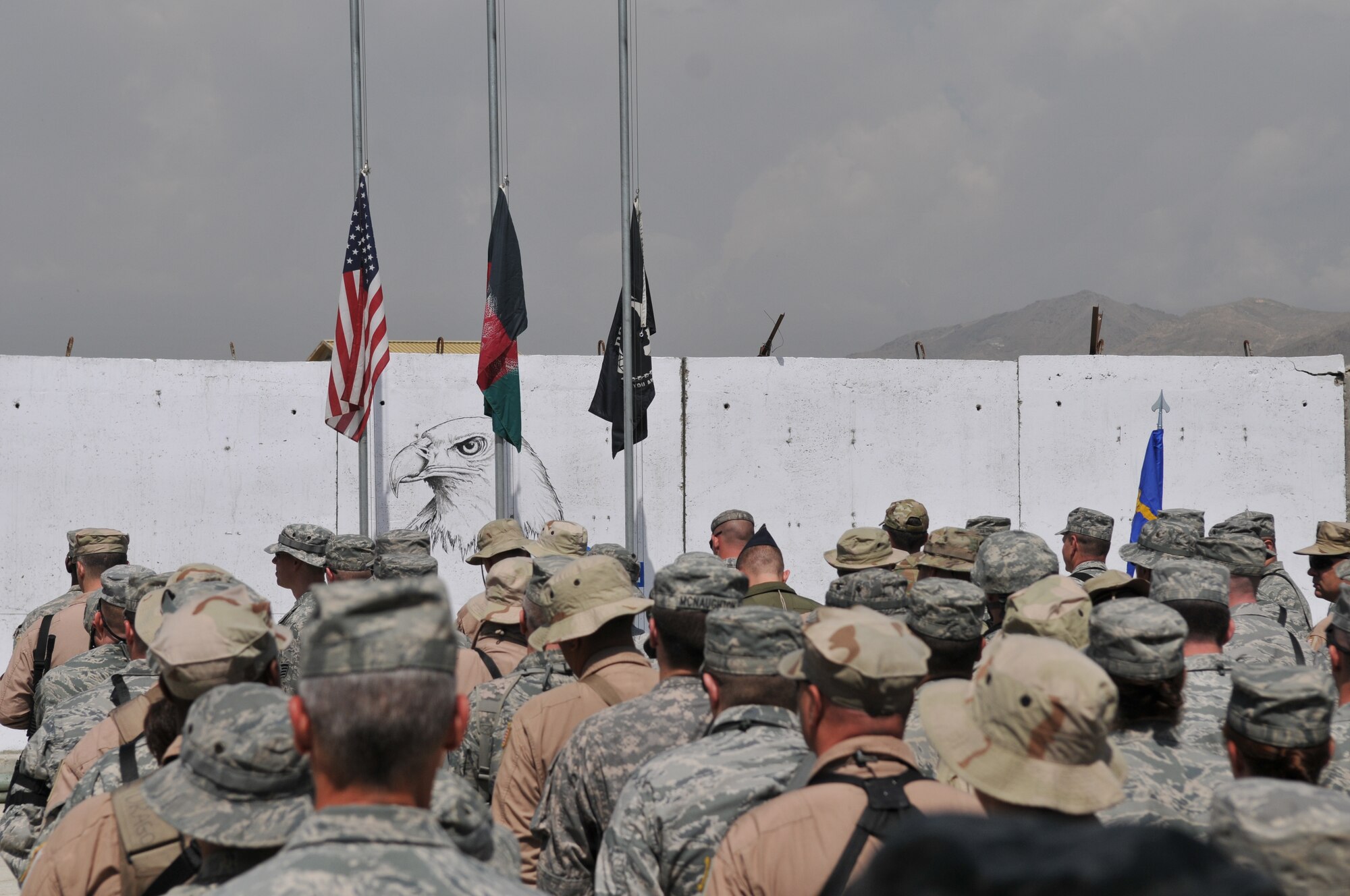 KABUL, Afghanistan -- U.S. and NATO coalition forces stand in formation during a flag-raising ceremony at the 438th Air Expeditionary Wing May 6. The ceremony marked nine days to the hour when eight Airmen and one retired Army civilian contractor were killed when a gunman opened fire during a meeting with NATO trainers.  (U.S. Air Force photo by Tech. Sgt. Brian E. Christiansen)