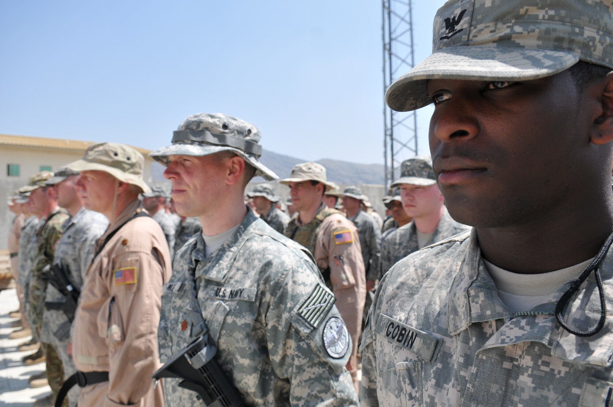 KABUL, Afghanistan -- U.S. and NATO coalition forces stand in formation during a flag-raising ceremony at the 438th Air Expeditionary Wing May 6. The ceremony marked nine days to the hour when eight Airmen and one retired Army civilian contractor were killed when a gunman opened fire during a meeting with NATO trainers.  (U.S. Air Force photo by Tech. Sgt. Brian E. Christiansen)