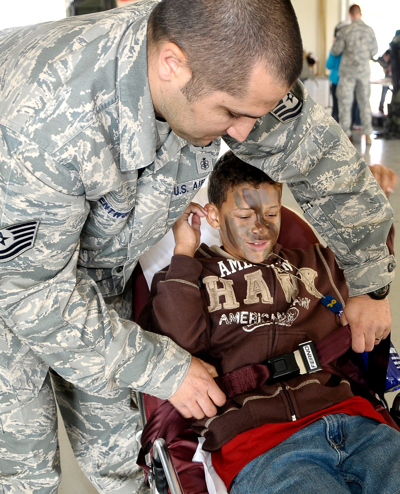 Tech. Sgt. Nick Wentworth, 31st Medical Group independent duty medical technician, helps a young boy buckle into a stretcher as part of a demonstration during the Aviano Children’s Deployment Line May 5. The 603rd Air Control Squadron hosted the simulated deployment line for children from Aviano elementary and middle schools, with help from volunteers from around the base, to help children better understand their parents’ duties in the military. (U.S. Air Force photo/Airman 1st Class Katherine Windish)