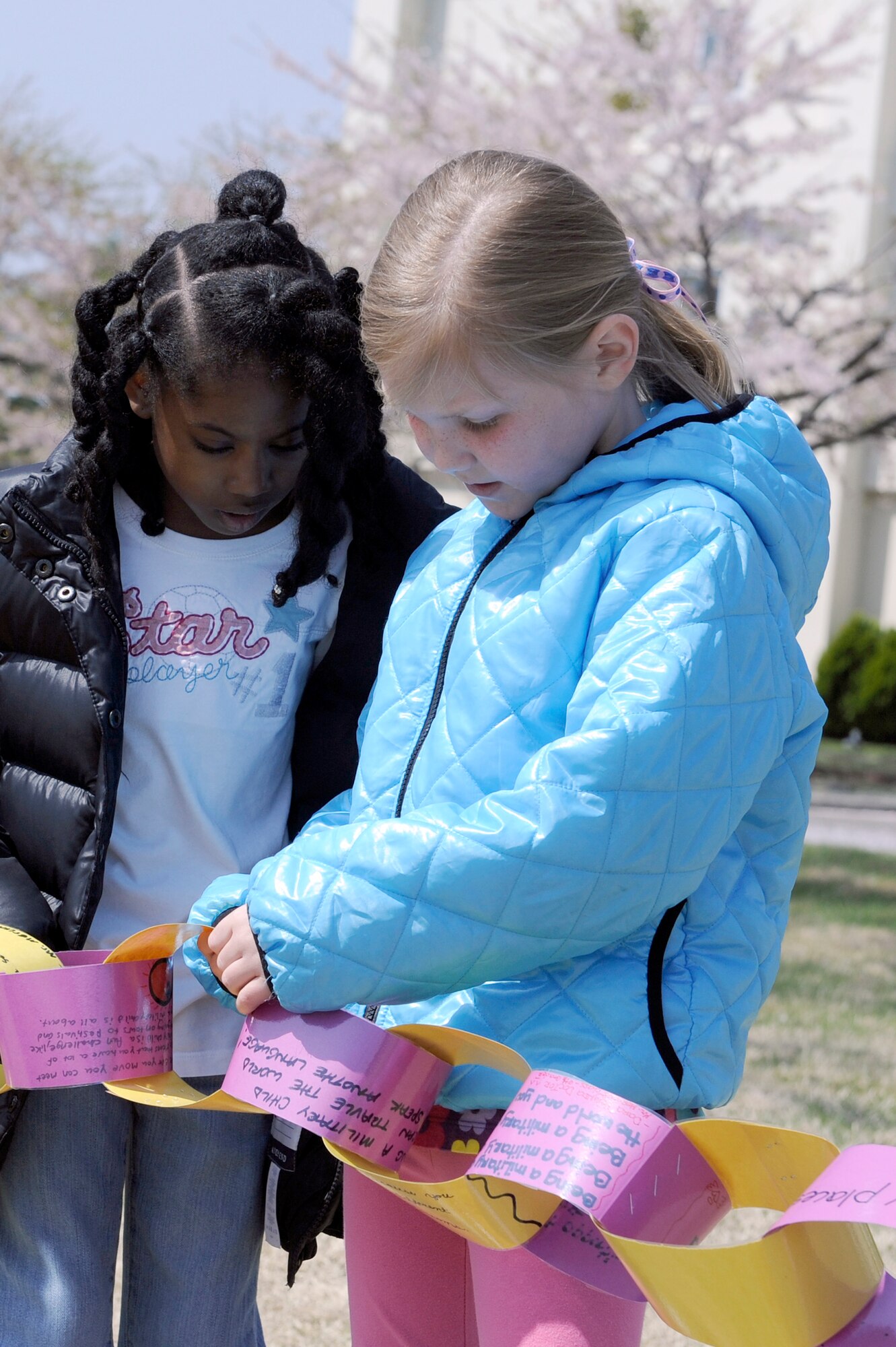 MISAWA AIR BASE, Japan -- Qua'Niya Jones, daughter of Tech. Sgt. Christopher Jones, 35th Security Forces Squadron, left, and Ashley Brough, daughter of Capt. Michael Brough, 35th Medical Operations Squadron, look at the different links made by their fellow classmates May 6. Approximately 165 children participated in a modified version of the "Lift, Link, Love" effort established by Like it For Time, an 
organization created to raise public awareness of the one percent of the American population shouldering a decade of continuous war. (U.S. Air Force photo/Staff Sgt. Marie Brown/Released)
