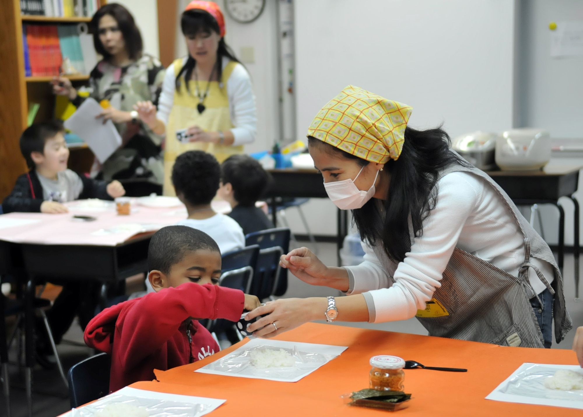 YOKOTA AIR BASE, Japan -- Mariko Crist, a volunteer for a multicultural event, helps Nasir Williams, a 1st grade student at Yokota West Elementary School, make a rice ball at Yokota Air Base, Japan, May 5, 2011. Onigiri, also known as rice balls, is a Japanese tradition. (U.S. Air Force photo/Airman 1st Class Krystal M. Garrett) 