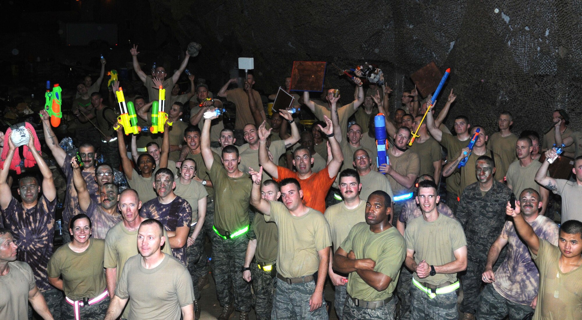 Airmen from the 379 Expeditionary Civil Engineer Squadron pose for a picture during the closing moments of the Combat Dining In event 4 May in Southwest Asia. Many Airmen from the ECES participated in the evenings events. (U.S. Air Force photo/ Staff Sgt Anthony Graham)