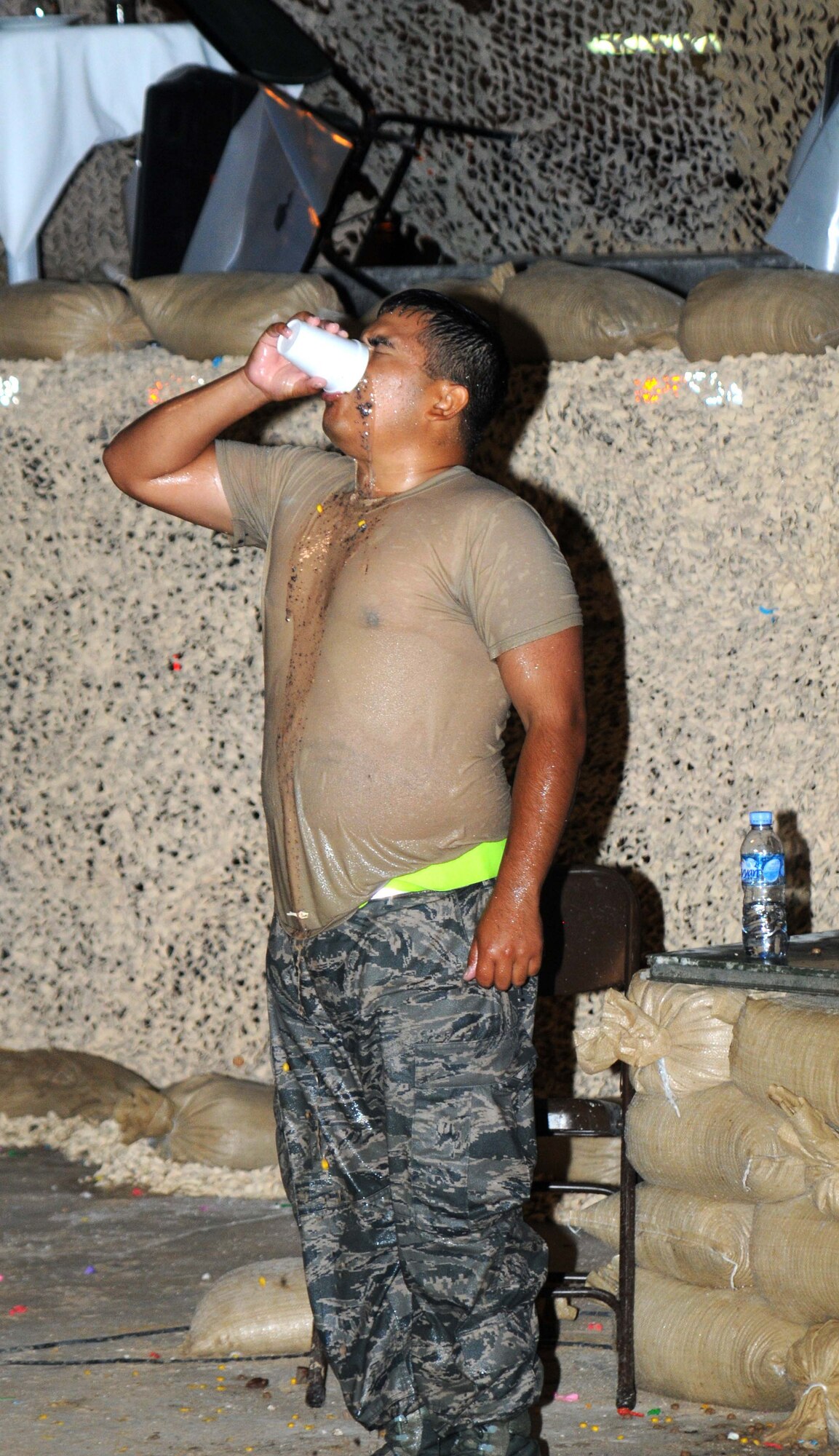 Senior Airman Julian Pina from the 379 Expeditionary Civil Engineer Squadron drinks a cup from the grog  May 4 in Southwest Asia.  The grog is a part of the event and contains different ingredients brought from different squadrons. (U.S. Air Force photo/ Staff Sgt. Anthony Graham)