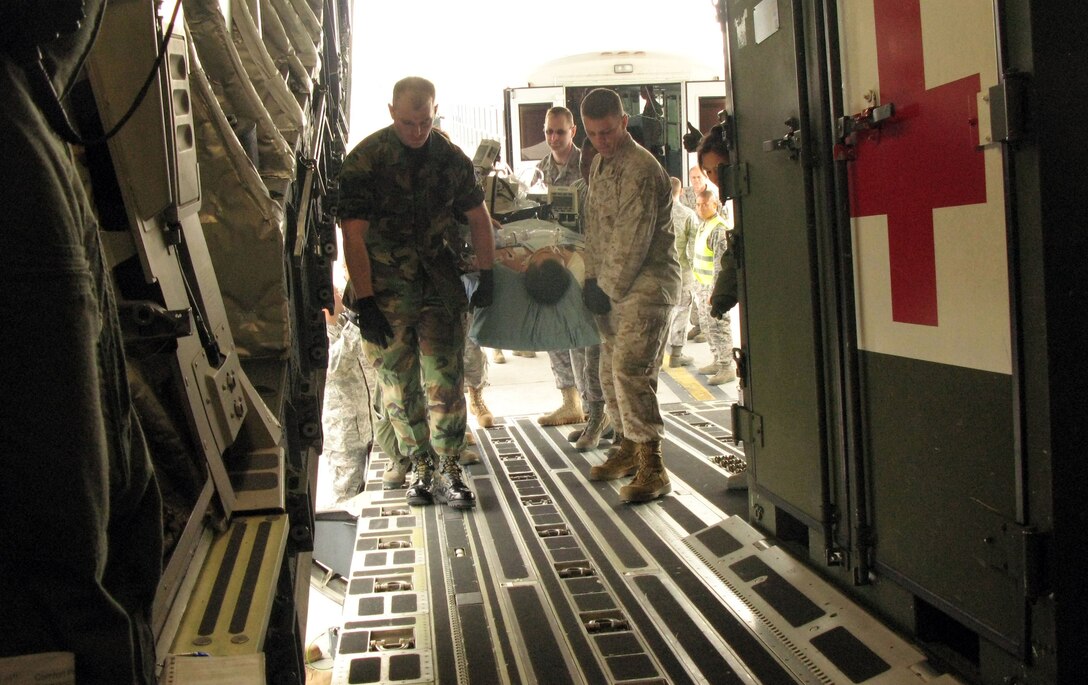 Aeromedical evacuation team members and volunteers at Ramstein Air Base, Germany, carry a patient being transferred from Landstuhl Regional Medical Center for a C-17 Globemaster III flight to Joint Base Andrews, Md., to receive care at Walter Reed Army Medical Center in Washington, D.C., April 29, 2011. DOD photo by Donna Miles