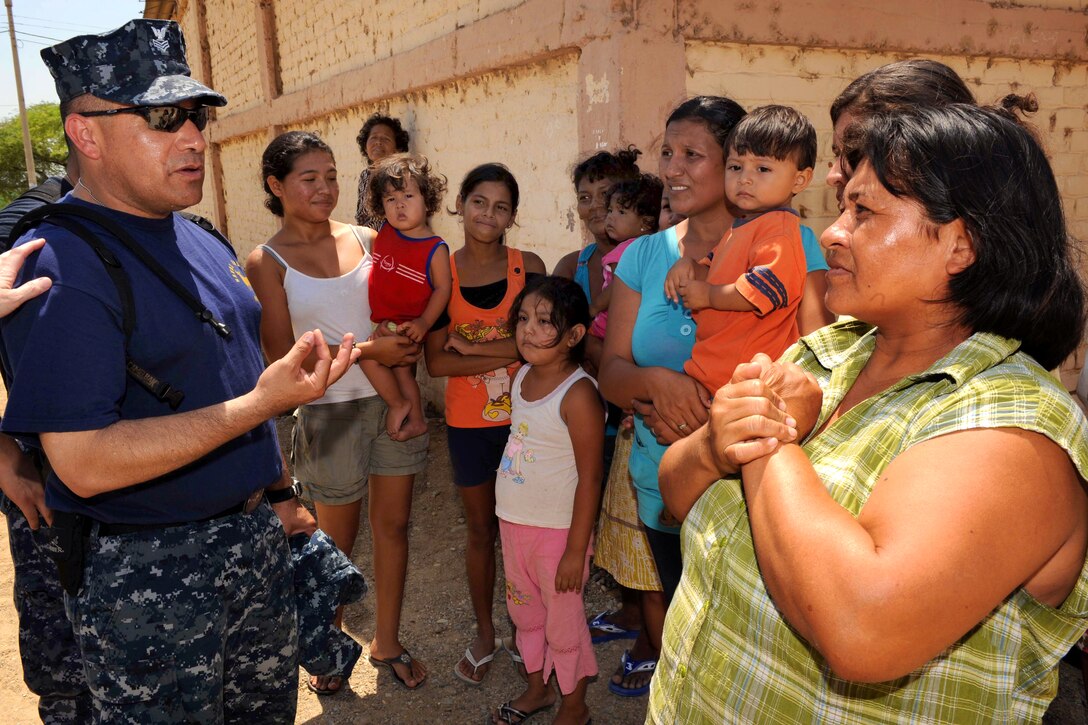U.S. Navy Petty Officer 1st Class Carlos Aguilar speaks with a group of Peruvian citizens outside a temporary medical clinic during Continuing Promise in Paita, Peru, May 2, 2011. Aguilar is a hospital corpsman.