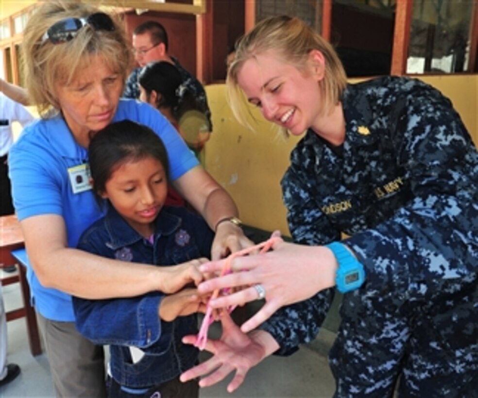 Sheryl Flanary (left) and U.S. Navy Lt. j.g. Sara Edmonson (right) teach a patient how to play a game at a medical clinic set up by the staff of the hospital ship USNS Comfort (T-AH 20) for Continuing Promise 2011 in Paita, Peru, on May 3, 2011.  Continuing Promise is a regularly scheduled mission to countries in Central and South America and the Caribbean, where the U.S. Navy and its partnering nations work with host nations and a variety of governmental and nongovernmental agencies to train in civil-military operations.  