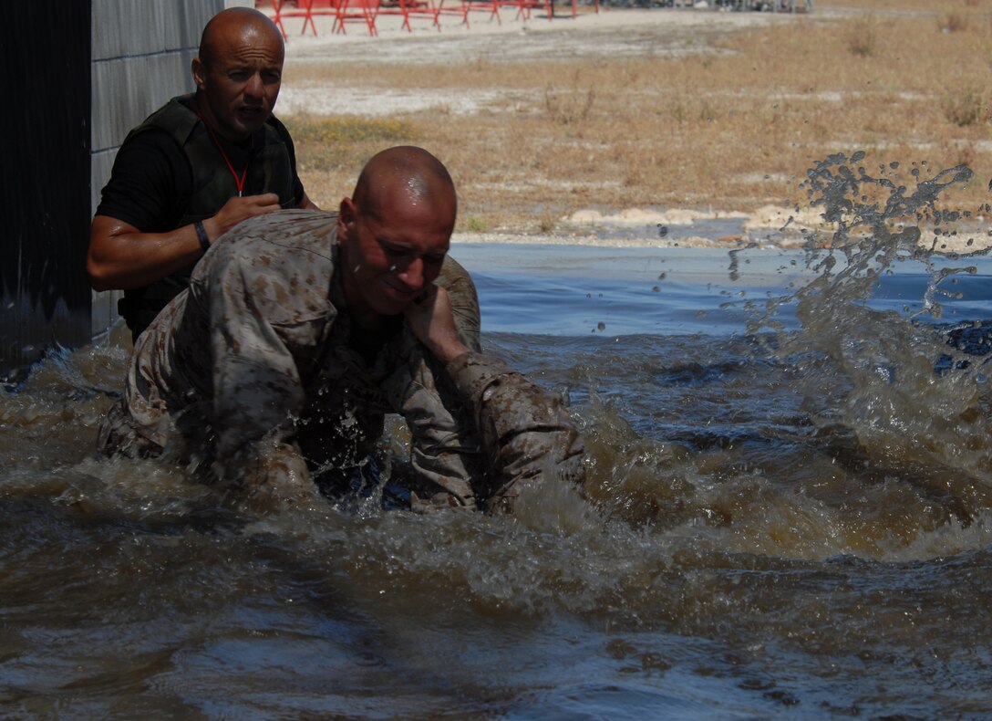 Staff Sgt. David O. Gonzalez, chief instructor, Martial Arts Training Facility, supervises Sgt. Thoedoor A. Steber and his unidentified opponent as they engage in a bout in a flooded facility on the depot. Steber, a drill instructor with Company K, submerges his partner to win the match.
