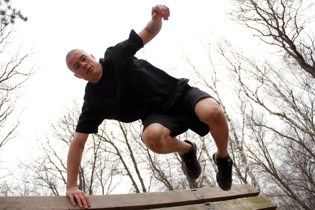 Martin Bottila, a 17-year-old junior at Forrest Lake High School, clears a reverse-slanting wall while running through an obstacle course during the Recruiting Station Twin Cities mini boot camp May 7. Bottila attended the three-day boot camp as a guest out of the Coon Rapids recruiting office. For additional imagery from the event, visit www.facebook.com/rstwincities.