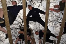 Sgt. Alan J. Koehler, a 29-year-old Elk River, Minn., native and recruiter out of the Coon Rapids office, watches members of the Delayed Entry Program and guests climb through the log pyramid portion of an obstacle course during the Recruiting Station Twin Cities mini boot camp May 7. Each group ran through the course multiple times to master every station. For additional imagery from the event, visit www.facebook.com/rstwincities.