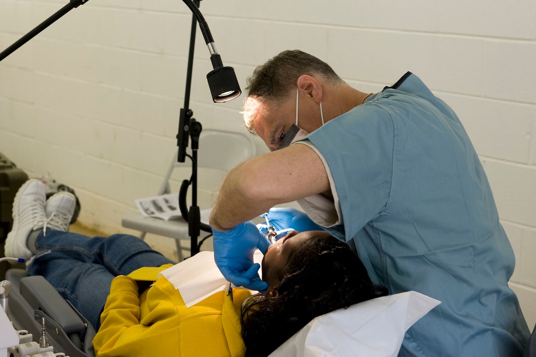 HAYNEVILLE, Ala. - Maj . Michael Majchrowicz, a dentist with the 176th Medical Group, Alaska Air National Guard, works on a patient, May 5, 2011. Majchrowicz and about thirty-five other members from the Wing are in Alabama for an Innovative Readiness Training (IRT) mission.  The IRT program allows for real world training opportunities for military personnel while providing needed services to under-served communities in the United States. The Shower kits will be used by the men of the group during the 10-day mission.  Alaska Air National Guard photo by Master Sgt. Shannon Oleson.