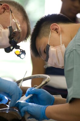 HAYNEVILLE, Ala. - U.S. Navy Commander Dan Ratkus, a dentist with Volunteer Training Unit at the Naval Operational Support Command, Phoenix, Az.  and Senior Airman Daniel Micelli, a dental technician with the 176th Medical Group, Alaska Air National Guard, work on a patient, May 5, 2011. Ratkus and Micelli are in Alabama along with about sixty other medical professional from numerous military components and services for an Innovative Readiness Training (IRT) mission. The IRT program allows for real world training opportunities for military personnel while providing needed services to under-served communities in the United States. Alaska Air National Guard photo by Master Sgt. Shannon Oleson.