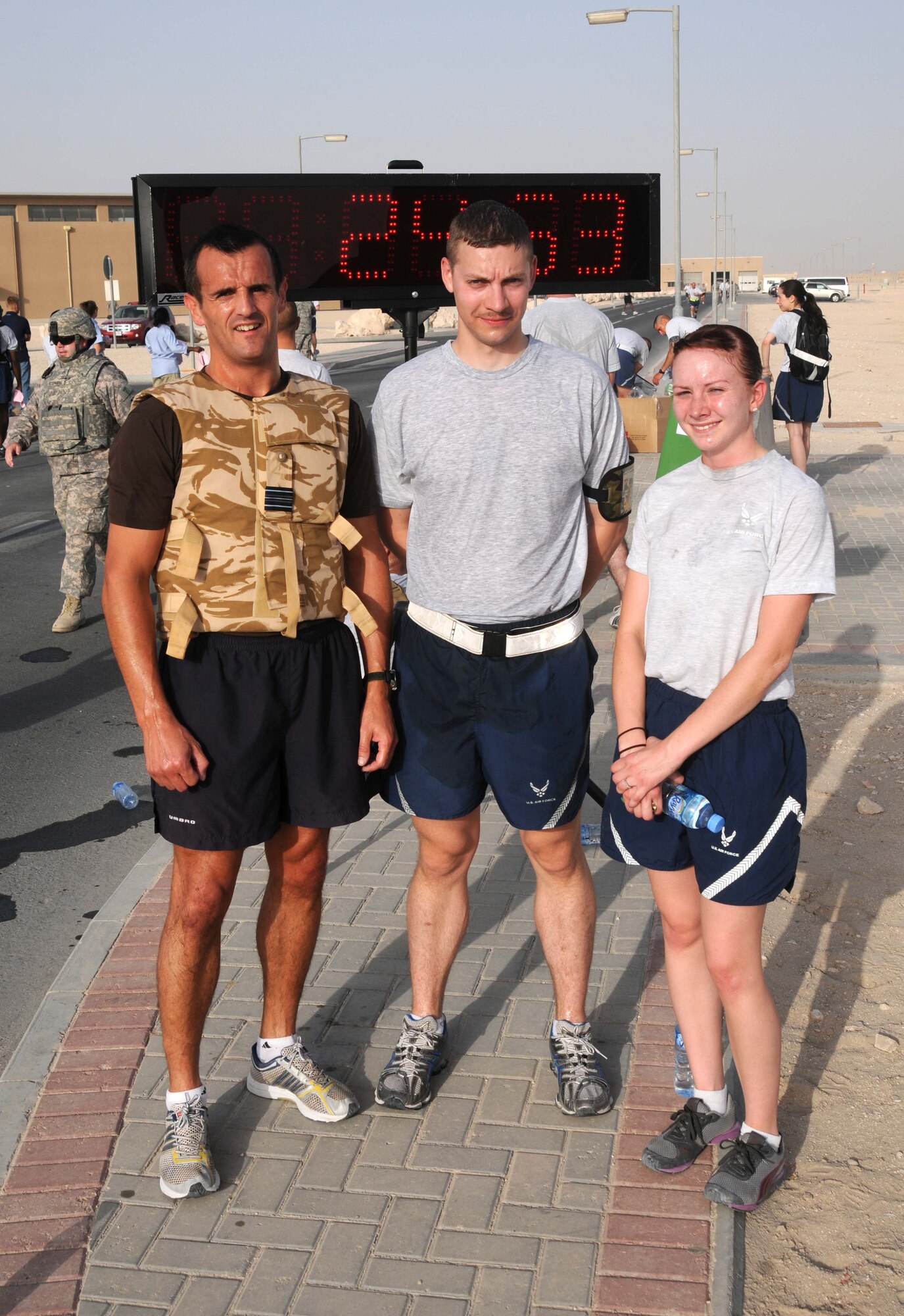 Squadron Leader Mark Hinde, Airman 1st Class Todd Sever and Senior Airman Kara Kwiatkowski pose for a photo after the 379th Expeditionary Civil Engineering Squadron Explosive Ordinance Disposal team sponsored  5 km run in Southwest Asia.  The three individuals were the top three finishers of the race. (U.S. Air Force photo/ Staff Sgt Anthony Graham)