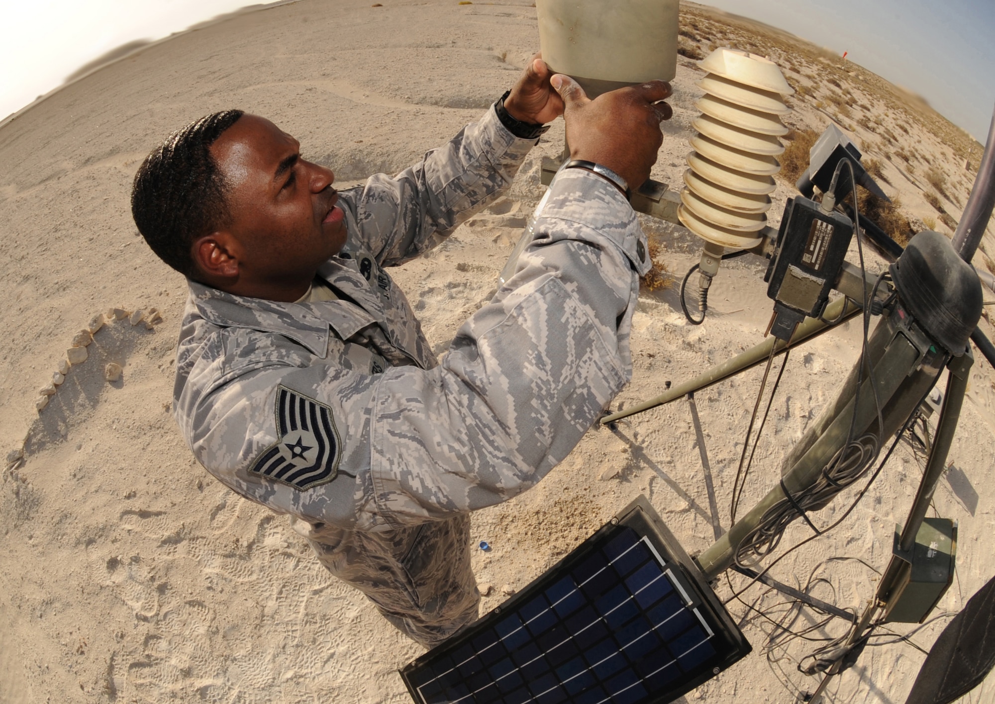 Tech. Sgt. Shannon Byers, 380th Expeditionary Operations Support Squadron, inspects the rain gauge on the AN/TMQ-53 Tactical Meteorological Observing System Mar. 11, 2011. The Iridium-based system allows the teams to start transmitting weather data from any location on the globe within an hour of arrival. (U.S. Air Force photo by Senior Airman Maynelinne De La Cruz)
