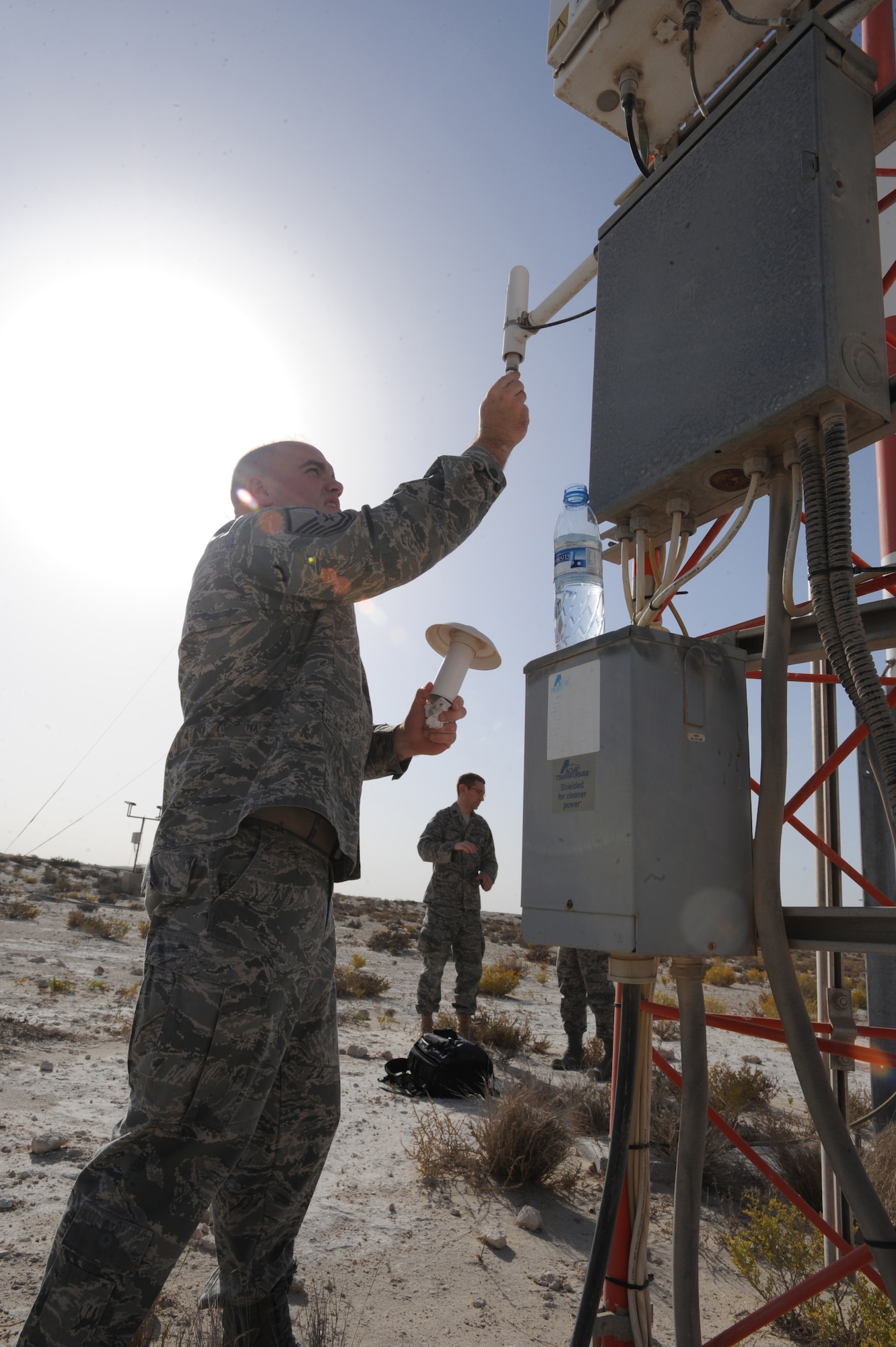 Master Sgt. Jason Ronsse, 380th Expeditionary Operations Support Squadron, removes dust and debris from the FMQ-19 Automatic Observation System's housing unit Mar. 11, 2011. This ensures air flow to the sensors is not blocked, guaranteeing the most accurate data available. Weather changes are critical; even a small temperature shift can alter how much fuel a KC-10 aircraft can carry on a mission. (U.S. Air Force photo by Senior Airman Maynelinne De La Cruz)