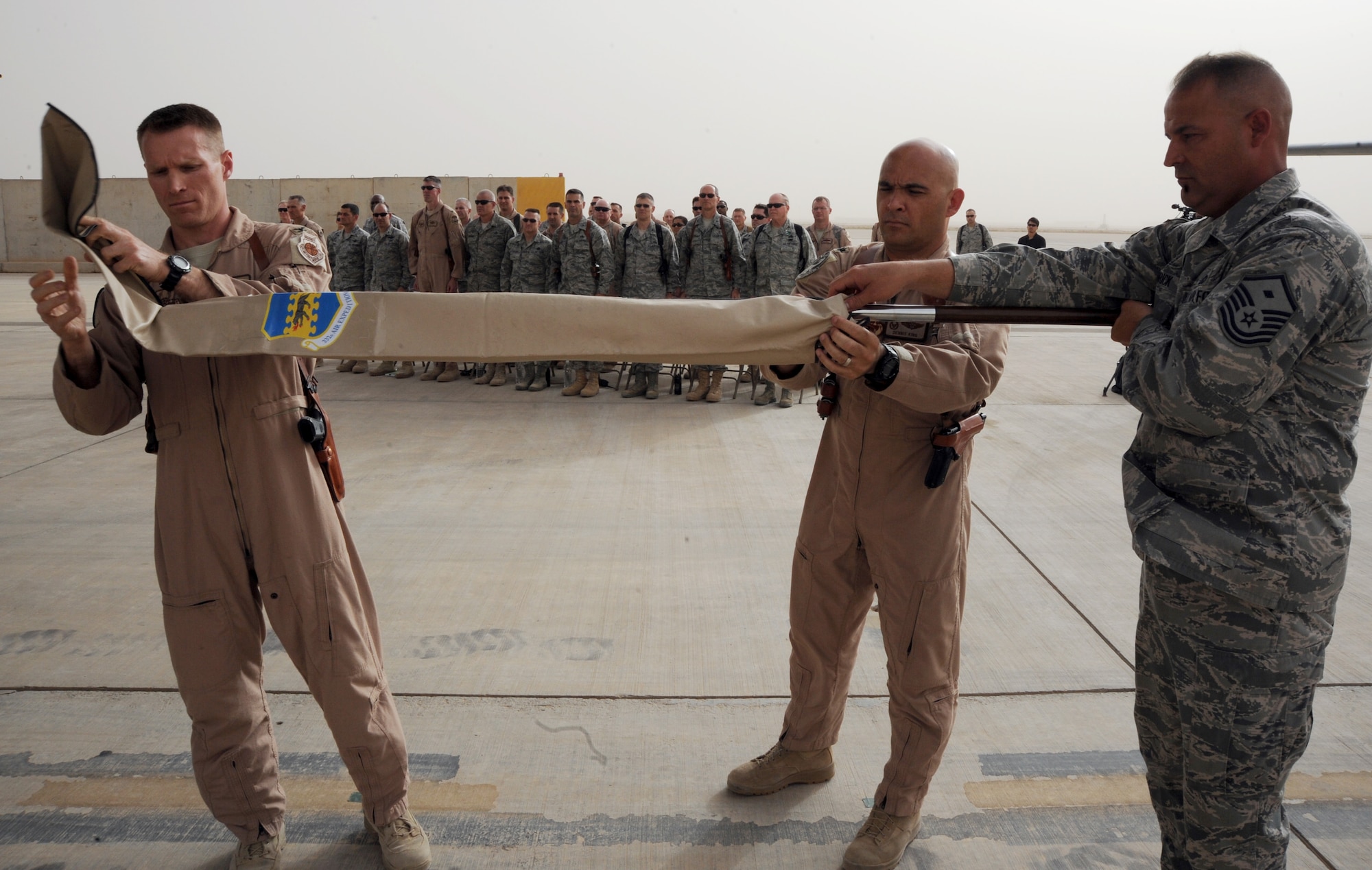 JOINT BASE BALAD, Iraq-- Colonel Lance Landrum, left, 332nd Expeditionary Operations Group commander, and Lt. Col. Dennis King, middle, 777th Expeditionary Airlift Squadron commander, encase the 777th EAS flag as a symbol of the squadron’s inactivation May 6, 2011. (U.S. Air Force photo/Staff Sgt. Keyonna Fennell)
