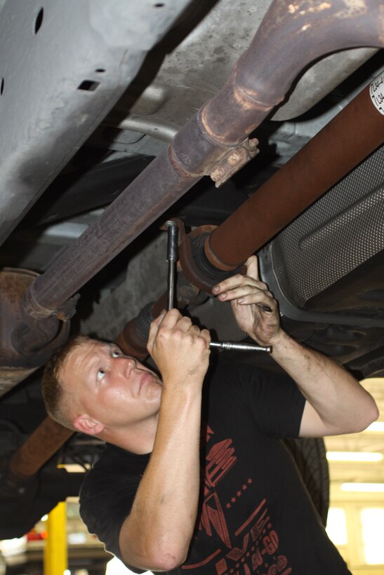 Staff Sgt. Nicholas Ouellette, a musician for Marine Band San Diego, works on changing a transmission seal on his 2007 Ford F-150 May 7 at the Auto Skills Center aboard Marine Corps Recruit Depot San Diego. The center provides equipment for servicemembers to work on their own cars to save money.