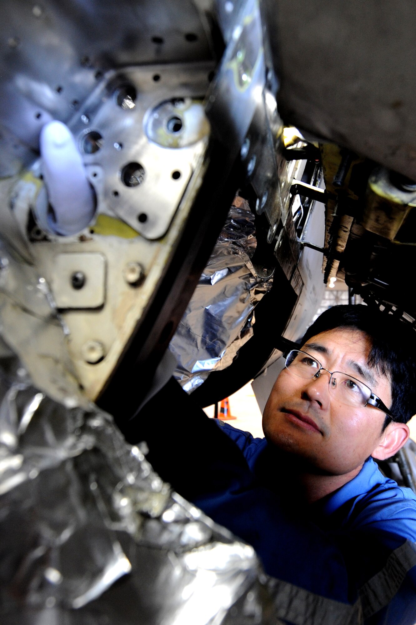 MISAWA AIR BASE, Japan -  Mr. Dong Woo Park, a member of the Korean Airline depot team from Gimhae, Korea, lines up the holes of the bulkhead structure with the support plates on an F-16 model 50 Fighting Falcon aircraft May 4.  As the aircraft ages, minor cracks occur in the bulkheads that require repair.  By bringing in the KAL depot team, the base is able to save approximately $500,000.  (U.S. Air Force Photo Staff Sgt. April Quintanilla)