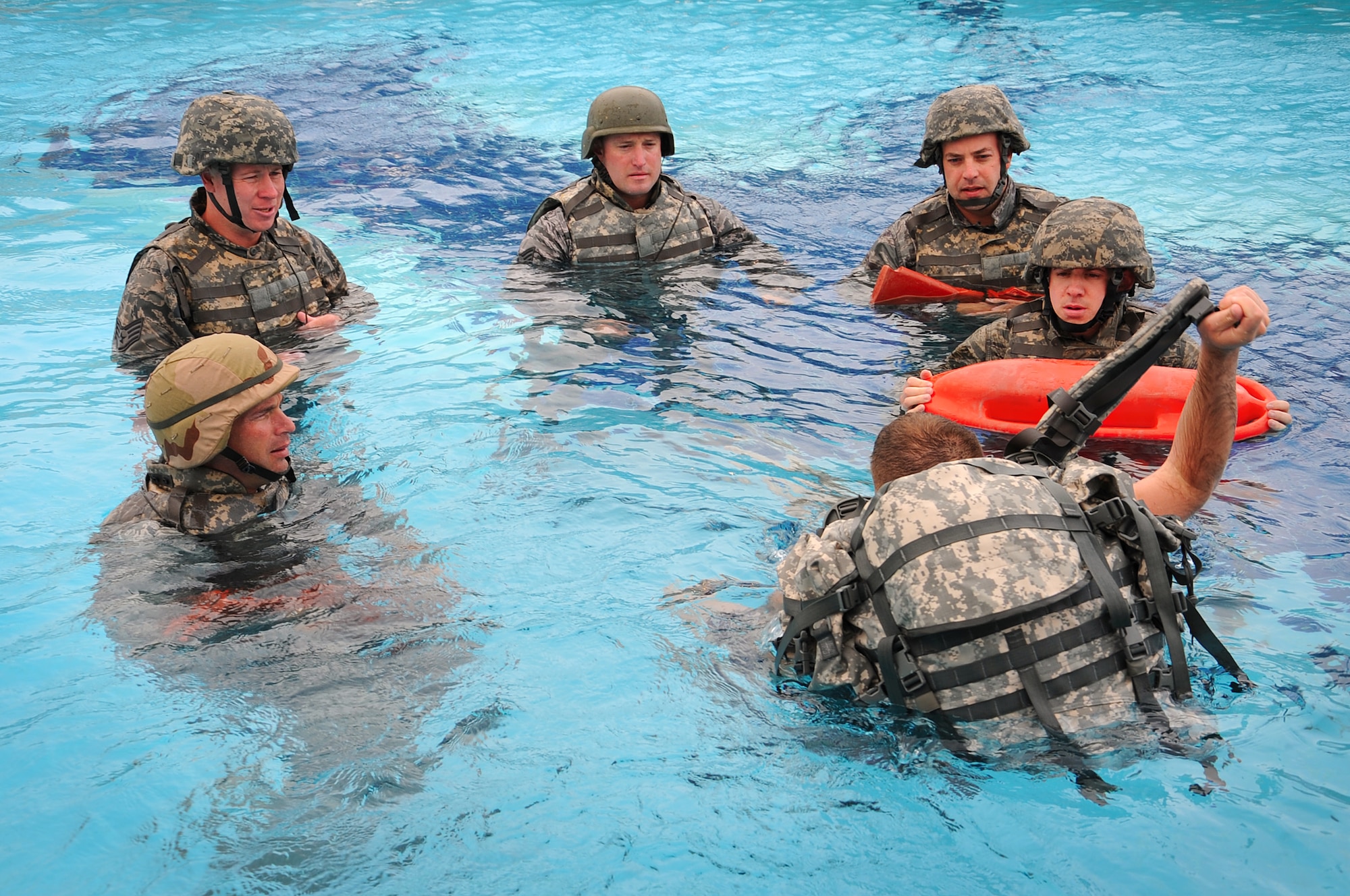 Tech. Sgt. Adam May demonstrates how to remove your pack after you have entered the water during Marine combat water survival training. Members of the fire department participated in this training to receive a combat water survival certification. Sergeant May is a firefighter deployed with the 386th Expeditionary Civil Engineer Squadron. (U.S. Air Force photo by Senior Airman Cynthia Spalding) 