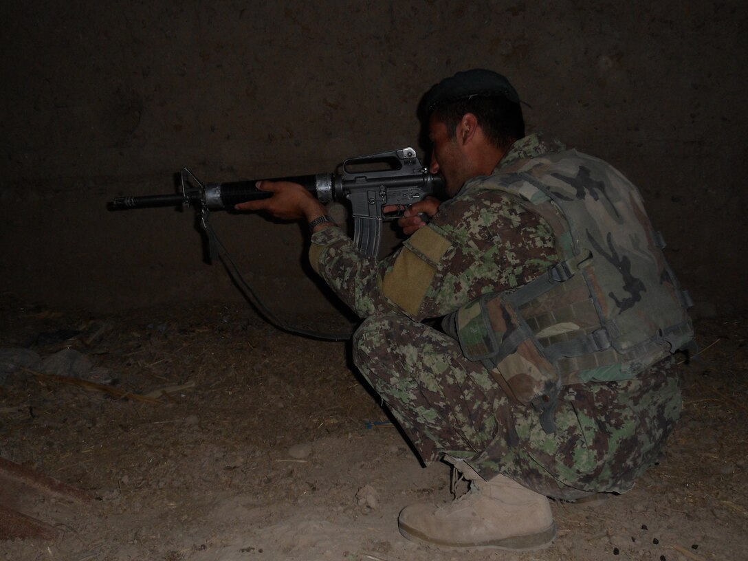 An Afghan National Army soldier holds security on the entrance of a compound during a joint listening and observation post, May 9. Marines with 2nd Platoon, Company C, 1st Battalion, 5th Marine Regiment, used the opportunity to show their ANA counterparts trust and wanted to work with them to improve partnership in Sangin, Afghanistan.