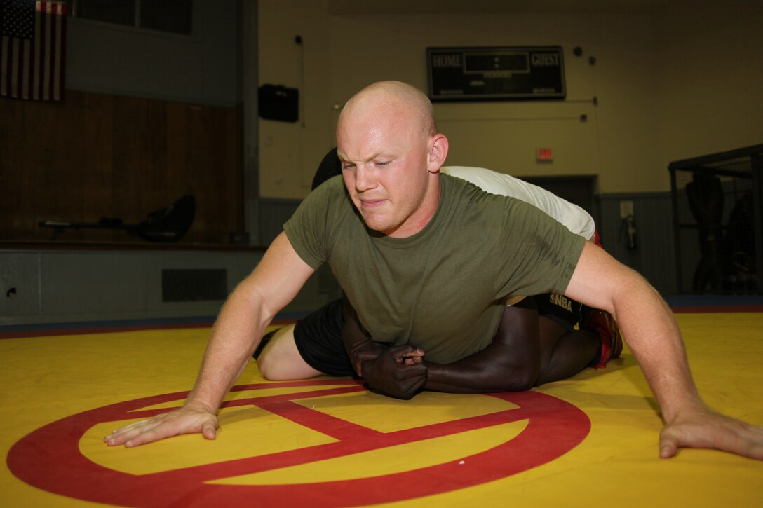 Lance Cpl. Steven T. Smiley attempts to defend against getting rolled over by Cpl. Donte L. Ravenell during their practice in the wrestling room aboard Marine Corps Base Camp Lejeune May 9. Smiley is the only Cherry Point Marine who is on the All-Marine wrestling team and finished fifth in his first international wrestling tournament. “As a Marine this is my job now,” said Smiley. “So to continue to push the envelope in my wrestling career is not only a passion of mine but also a way for me to continue to give back to an organization that has done so much for me. This is my duty to the Marine Corps, and I am happy to serve them by doing something I absolutely love.”