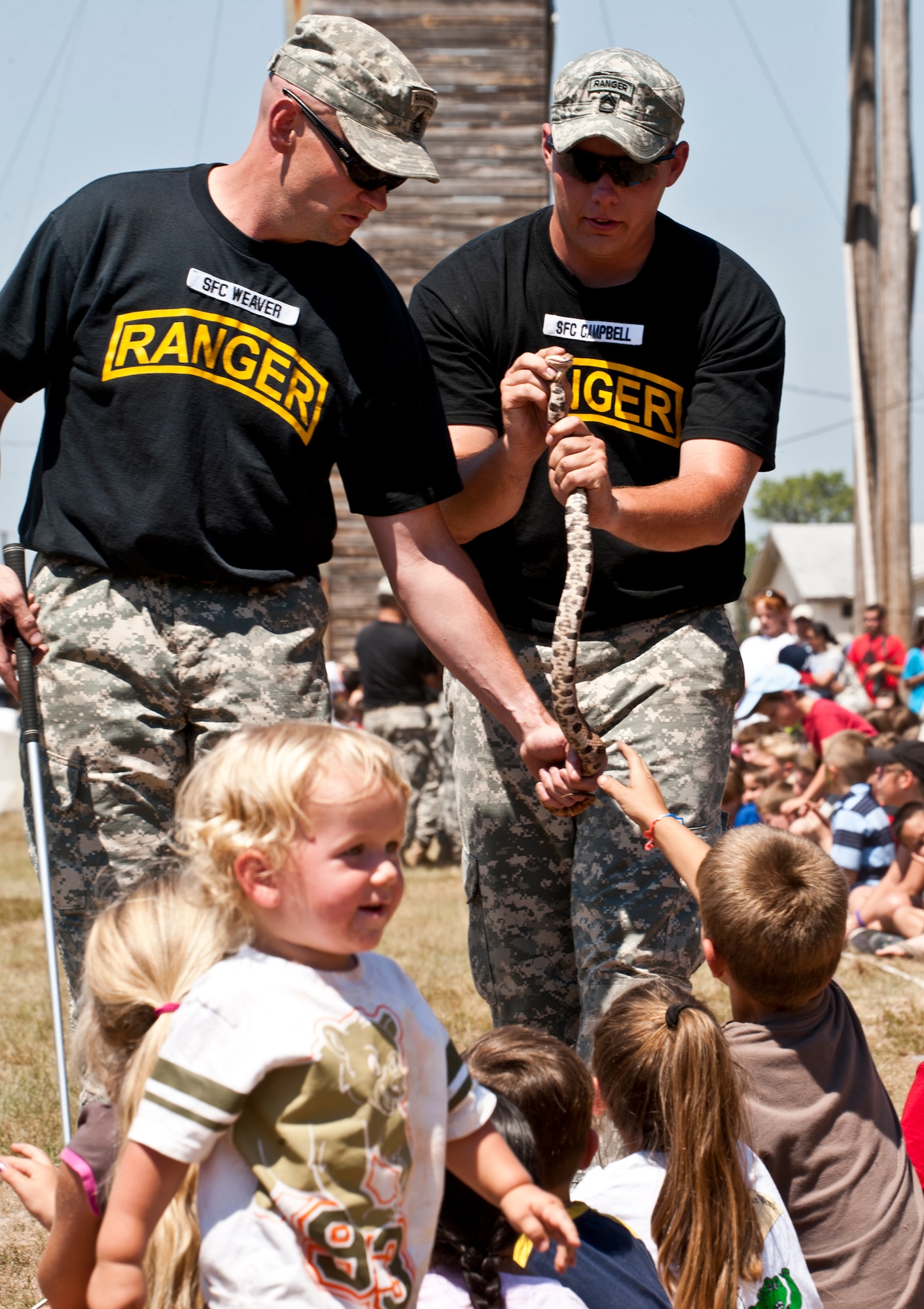 Sgts. 1st Class Jasan Weaver and Joshua Campbell, 6th Ranger Training Battalion, allow kids to see and touch a poisonous snake during the "snake show" portion of the 60th Anniversary Open House at the Ranger Camp May 7.  The event was a chance for the public to learn how Rangers train and operate in extreme situations. The event displays showed dive equipment, weapons, a reptile zoo and zodiac boats.  The demonstrations showed off hand-to-hand combat, a parachute jump, a down-pilot scenario and others. (U.S. Air Force photo/Samuel King Jr.) 