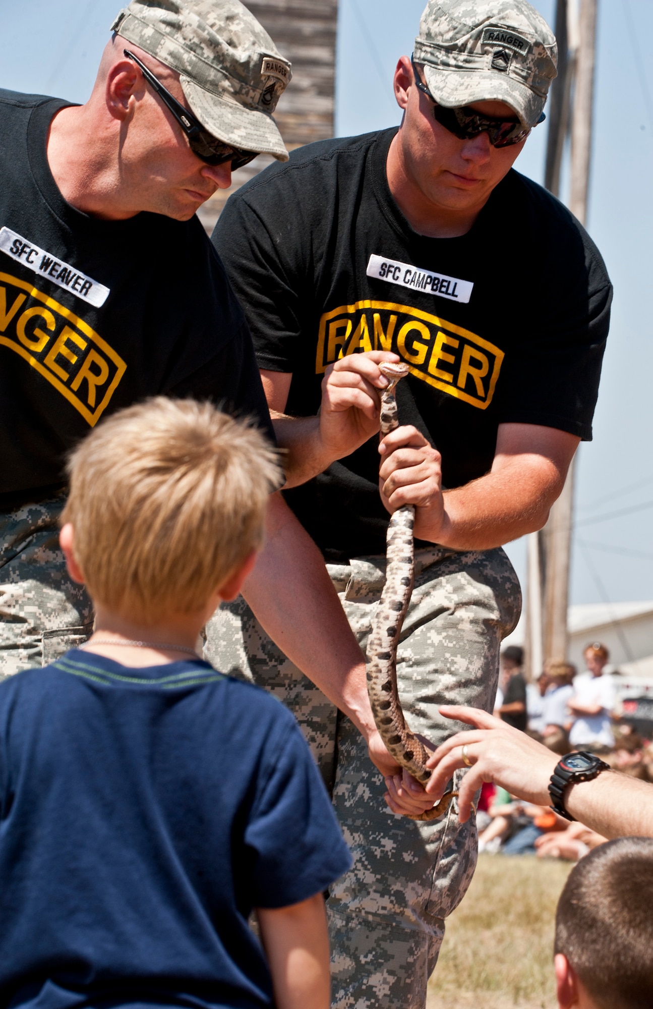 EGLIN AIR FORCE BASE, Fla. -- Sgts. 1st Class Jasan Weaver and Joshua Campbell, 6th Ranger Training Battalion, allow kids to see and touch a poisonous snake during the "snake show" portion of the 60th Anniversary Open House at the Ranger Camp May 7.  The event was a chance for the public to learn how Rangers train and operate in extreme situations. The event displays showed dive equipment, weapons, a reptile zoo and zodiac boats.  The demonstrations showed off hand-to-hand combat, a parachute jump, a down-pilot scenario and others. (U.S. Air Force photo/Samuel King Jr.) 