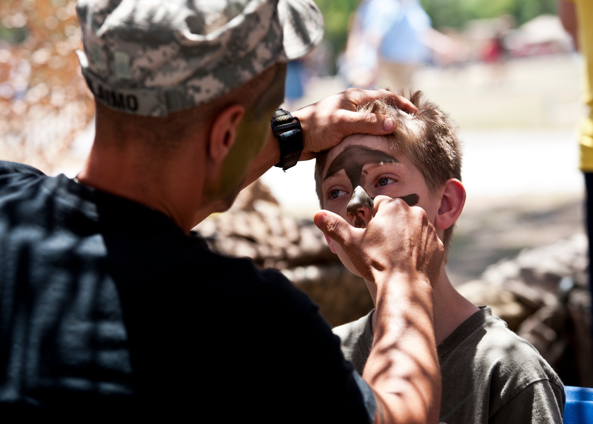 EGLIN AIR FORCE BASE, Fla. -- Spc. John Alaimo, 6th Ranger Training Battalion, applies some war paint to 10-year-old Zach Broxson, during their 60th Anniversary Open House event, May 7.  The event was a chance for the public to learn how Rangers train and operate in extreme situations. The event displays showed dive equipment, weapons, a reptile zoo and zodiac boats.  The demonstrations showed off hand-to-hand combat, a parachute jump, a down-pilot scenario and others. (U.S. Air Force photo/Samuel King Jr.) 