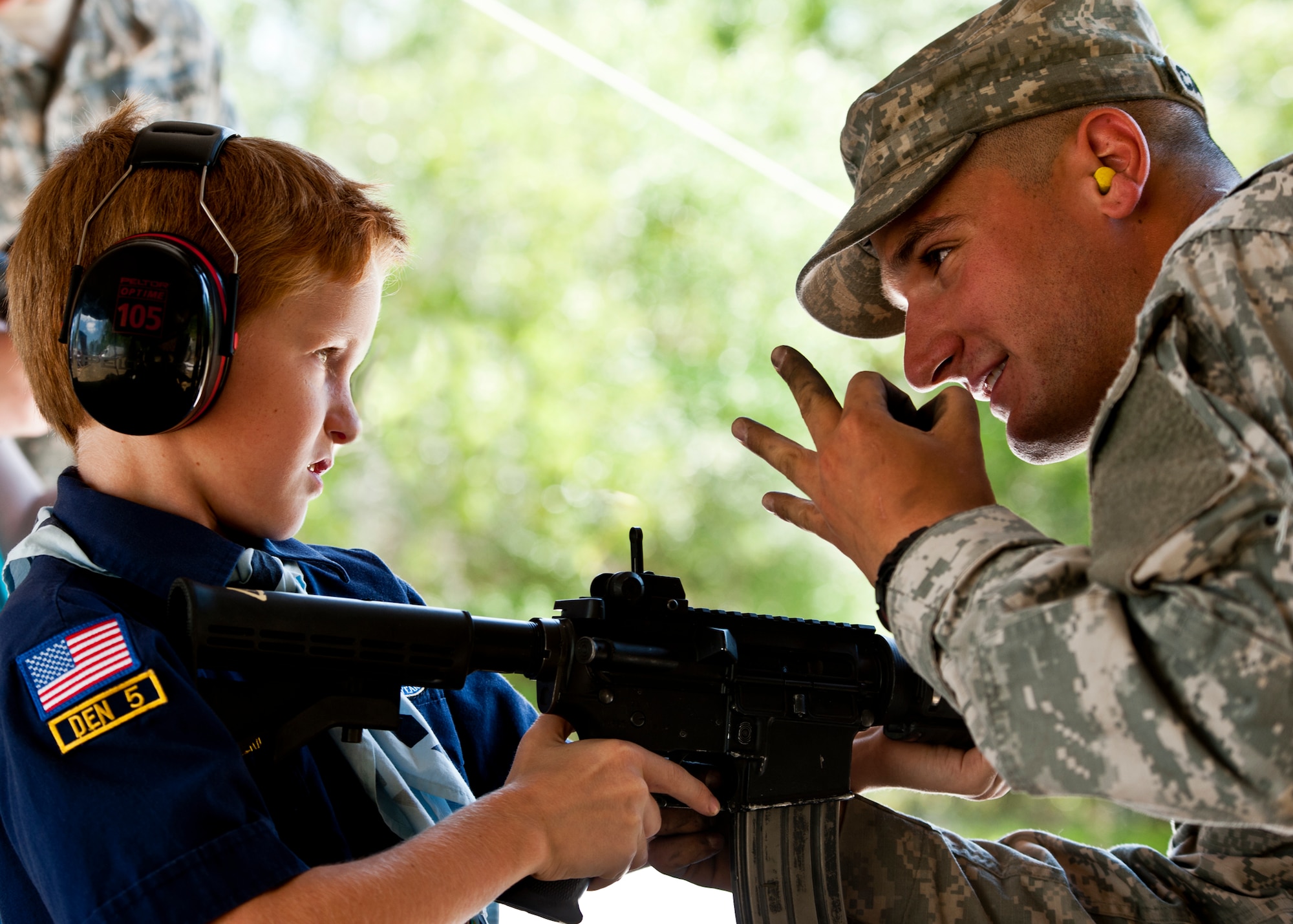 EGLIN AIR FORCE BASE, Fla. -- An Army Ranger explains the "burst" setting on an M-4 to a Cub Scout during the 6th Ranger Training Battalion's  60th Anniversary Open House event, May 7.  The event was a chance for the public to learn how Rangers train and operate in extreme situations. The event displays showed dive equipment, weapons, a reptile zoo and zodiac boats.  The demonstrations showed off hand-to-hand combat, a parachute jump, a down-pilot scenario and others. (U.S. Air Force photo/Samuel King Jr.) 