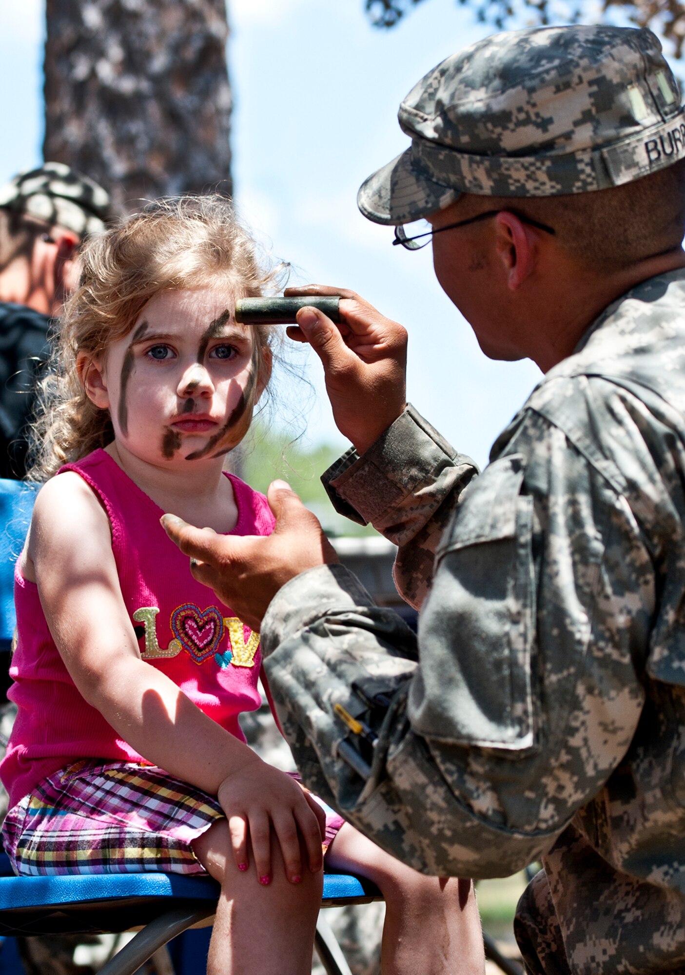 EGLIN AIR FORCE BASE, Fla. -- Four-year-old Katherine George has her tiger stripes applied by 1st Lt. David Burris, 6th Ranger Training Battalion, during their 60th Anniversary Open House event, May 7.  The event was a chance for the public to learn how Rangers train and operate in extreme situations. The event displays showed dive equipment, weapons, a reptile zoo and zodiac boats.  The demonstrations showed off hand-to-hand combat, a parachute jump, a down-pilot scenario and others. (U.S. Air Force photo/Samuel King Jr.) 