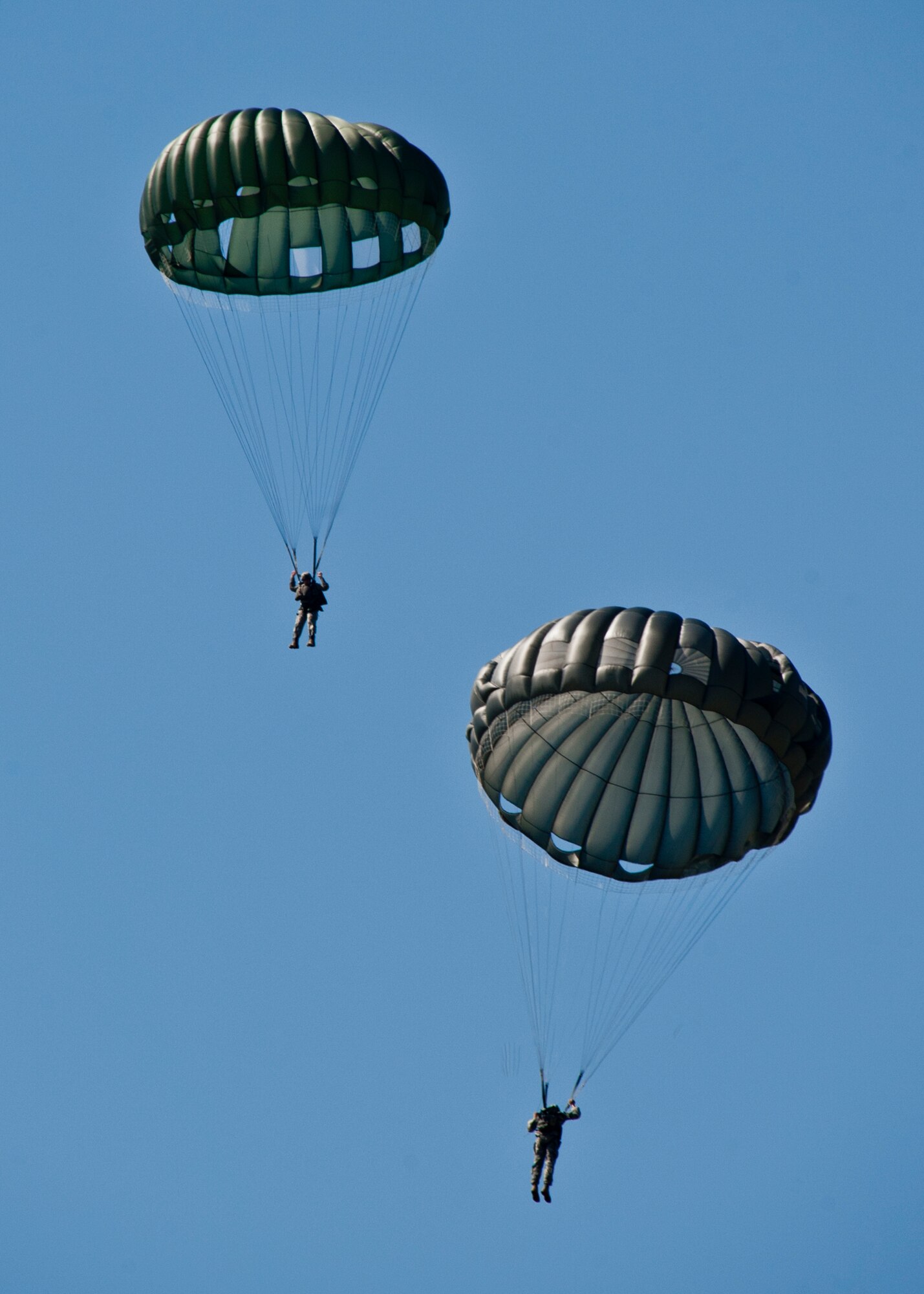 6th Ranger Training Battalion Rangers parachute down after leaping from a C-130 during the  their 60th Anniversary Open House event, May 7.  The event was a chance for the public to learn how Rangers train and operate in extreme situations. The event displays showed dive equipment, weapons, a reptile zoo and zodiac boats.  The demonstrations showed off hand-to-hand combat, a parachute jump, a down-pilot scenario and others. (U.S. Air Force photo/Samuel King Jr.) 
