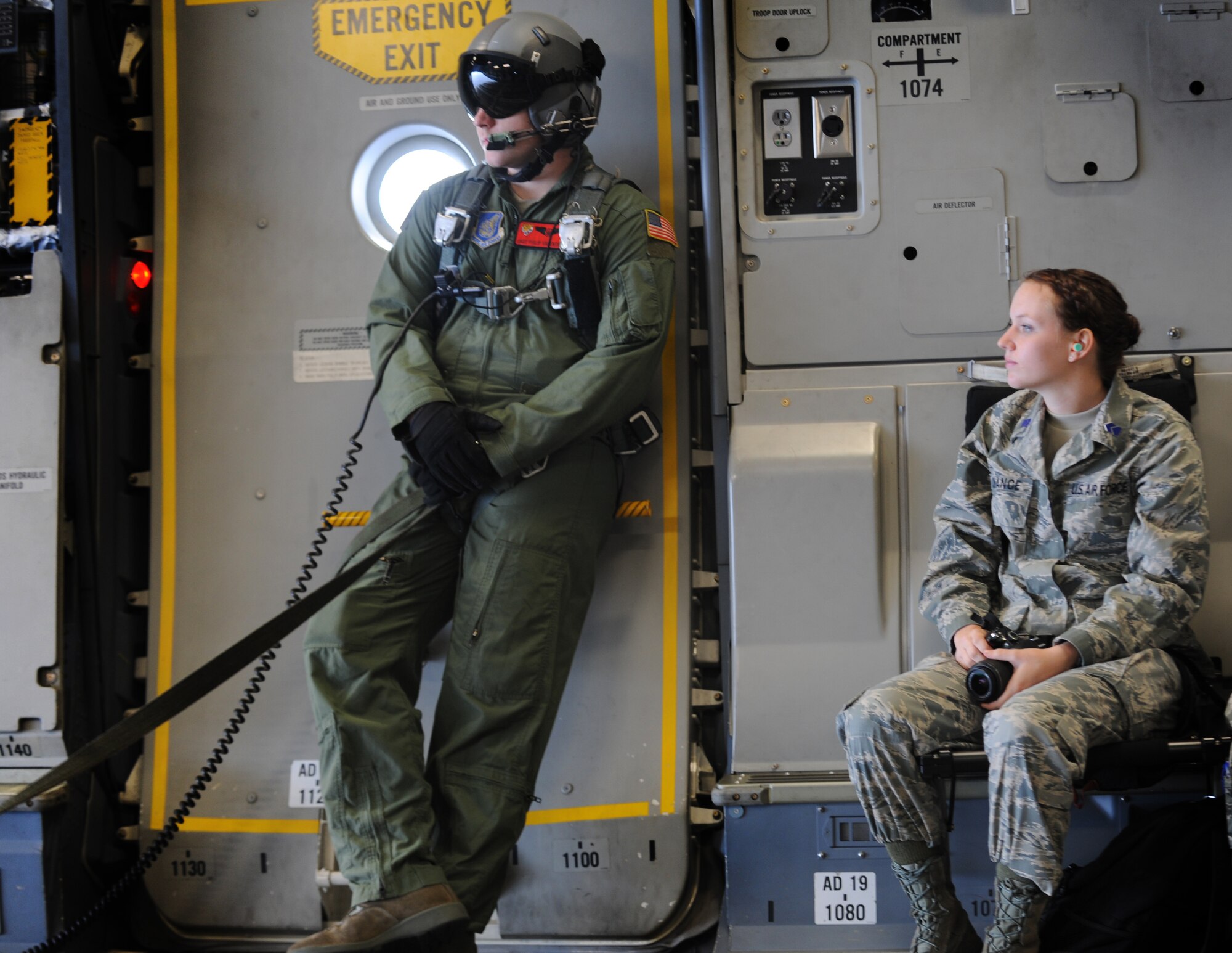 Staff Sgt. Philip Valenta, loadmaster with the 535th Airlift Squadron and Cadet Dakota Chance, Reserve Officer Training Corps cadet with University of Hawaii, enjoy the scenic views from the dropped ramp of a C-17 while in flight May 6. The flight contained more than 40 ROTC cadets from the University of Hawaii who were also able to experience and in-flight refueling mission. (U.S. Air Force photo/Senior Airman Lauren Main)
