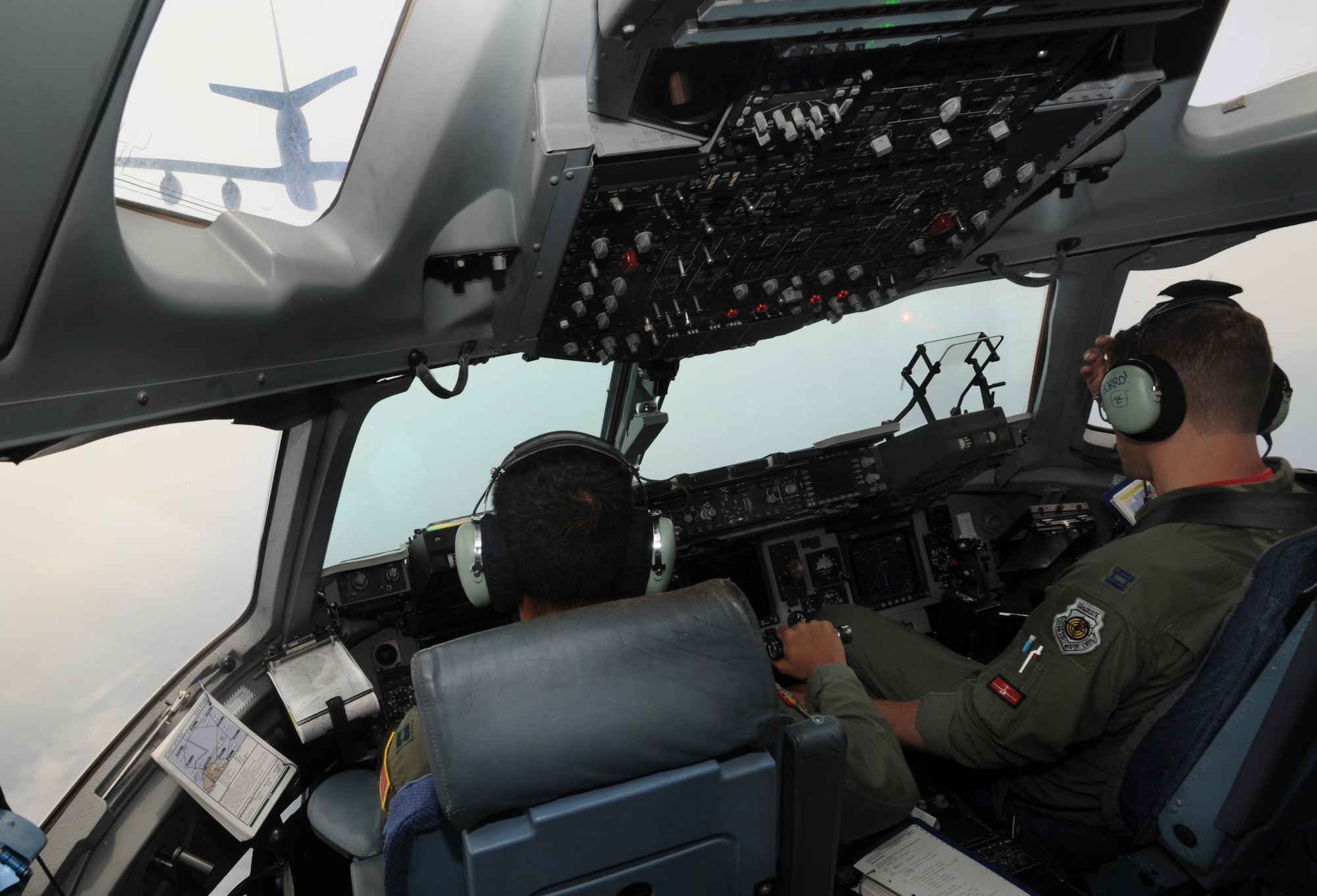 Capt. Justin Paulson and Capt. David Morales, C-17 pilots with the 535th Airlift Squadron, approach a KC-135 for air refueling training May 6. The flight contained more than 40 Reserve Officer Training Corps cadets from the University of Hawaii. During the flight, the cadets were able to witness the in-air refueling as well as the islands of Hawaii from the dropped ramp of a C-17. (U.S. Air Force photo/Senior Airman Lauren Main)