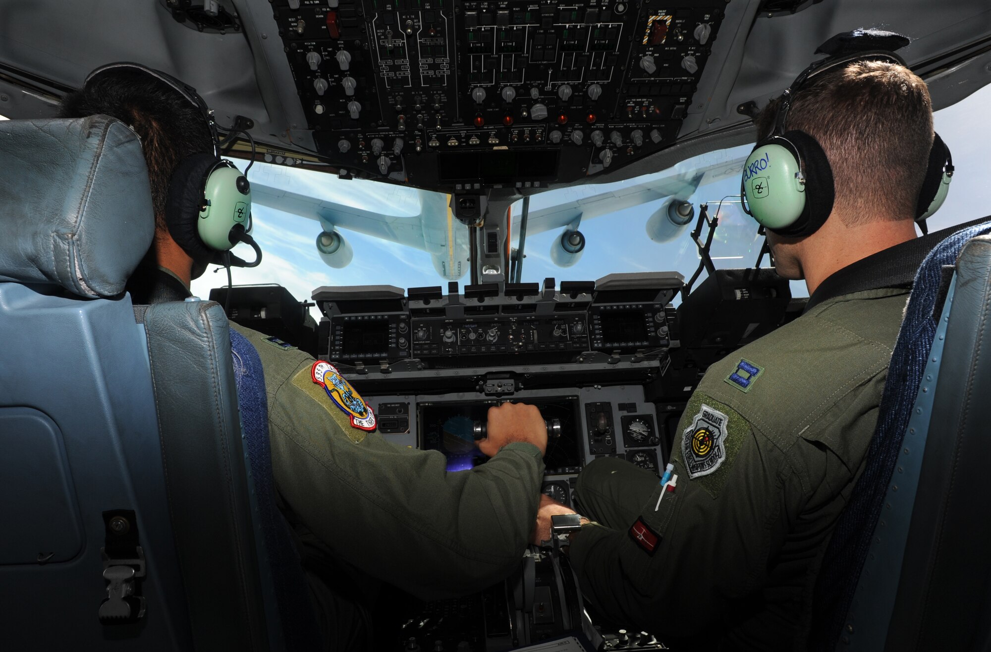 Capt. Justin Paulson and Capt. David Morales, C-17 pilots with the 535th Airlift Squadron, approach a KC-135 for air refueling training May 6. The flight contained more than 40 Reserve Officer Training Corps cadets from the University of Hawaii. During the flight, the cadets were able to witness the in-air refueling as well as the islands of Hawaii from the dropped ramp of a C-17. (U.S. Air Force photo/Senior Airman Lauren Main)
