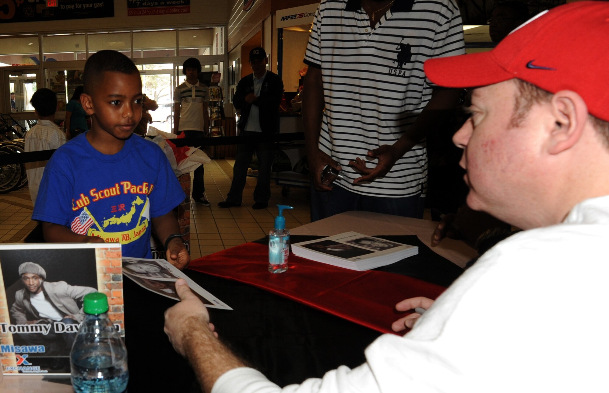 MISAWA AIR BASE, Japan --  Taj Lee, 8, accepts an autographed photo from comedian Rob Maher May 7.   Maher and comedian/actor Tommy Davidson came to the Misawa Air Base Exchange to meet base residents, take pictures and give out autographed photos to fans. (U.S. Air Force Photo by Staff Sgt. April Quintanilla)