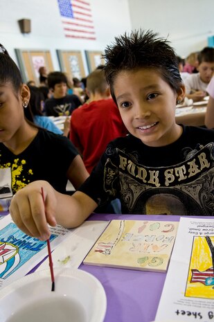 NELLIS AIR FORCE BASE, Nev. -- Liam Hurtado Carol, Lomie Heard Elementary School student and son of Staff Sgt. Iliana Hurtado, 99th Logistics Readiness Squadron Flight Service Center non-commissioned officer in charge, rinses his paintbrush off after painting on a ceramic tile May 5. More than 125 students were chosen to paint pictures on the tiles for a mural that will be displayed in the USO common room at the McCarran International Airport, Las Vegas. (U.S. Air Force photo by Airman 1st Class George Goslin)
