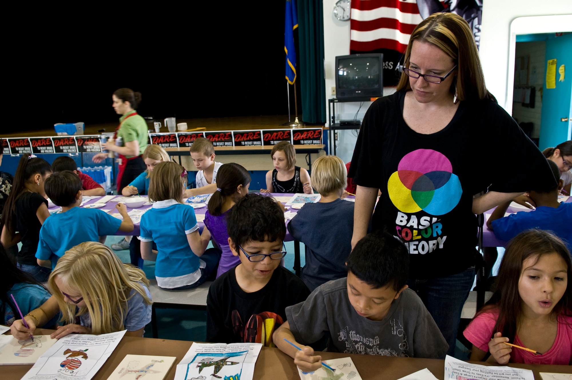 NELLIS AIR FORCE BASE, Nev. -- Andrea Mercer, Lomie Heard Elementary School art teacher, observes the students paintings in the multipurpose room of the school, May 5. More than 125 students were chosen to paint pictures on the tiles for a mural that will be displayed in the USO common room at the McCarran International Airport, Las Vegas. (U.S. Air Force photo by Airman 1st Class George Goslin)
