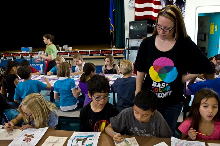 NELLIS AIR FORCE BASE, Nev. -- Andrea Mercer, Lomie Heard Elementary School art teacher, observes the students paintings in the multipurpose room of the school, May 5. More than 125 students were chosen to paint pictures on the tiles for a mural that will be displayed in the USO common room at the McCarran International Airport, Las Vegas. (U.S. Air Force photo by Airman 1st Class George Goslin)
