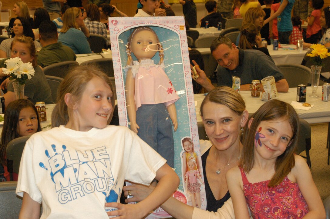 Joanna Masztalerz and her daughters pose with the door prize that they won at the Peterson AFB Deployed Families Dinner, hosted by the USAF Academy Band. Joanna's husband, MSgt Janusz Masztalerz, is deployed in SW Asia with Wild Blue Country from the USAF Academy Band.