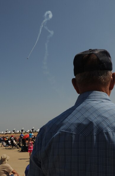 Air show attendee Mr. Jim Peadon observes a P-40 War Hawk performing during the 2011 Defenders of Liberty Air Show on Barksdale Air Force Base, La., May 7. The P-40 was used as a fighter plane during World War II. (U.S. Air Force photo/ Senior Airman Kristin High)(RELEASED)