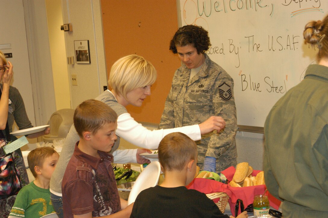 MSgt Sandra Tiemens serves food for the deployed families of Peterson AFB, Colorado. Melanie Oddo, wife of deployed bandsman SMSgt Jerome Oddo, and their two sons enjoyed food, music, and giveaways sponsored by the USAF Academy Band.