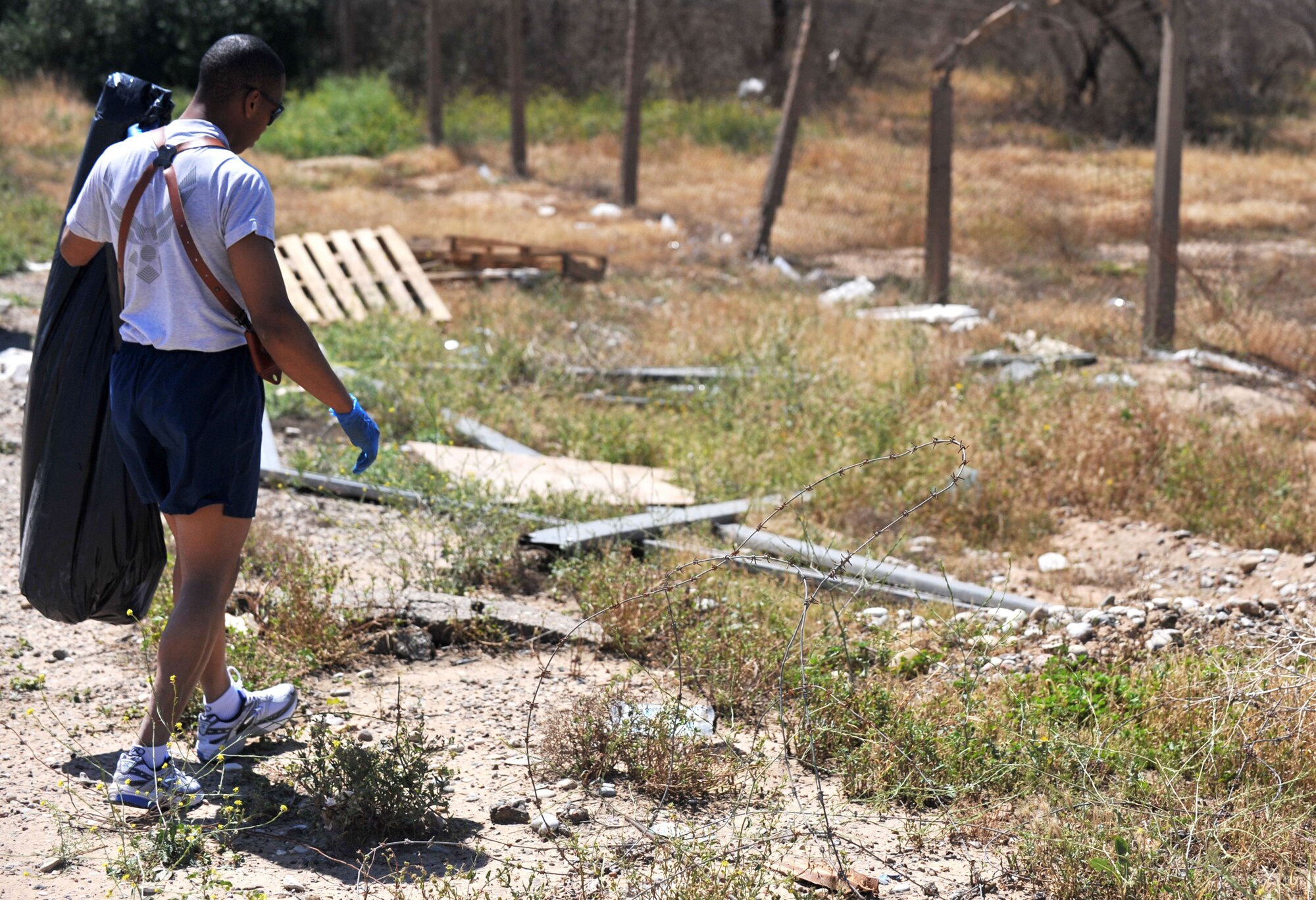 Senior Airman Troy Jenkins looks for trash to pick up off the side of the roads, April 24, 2011, at Contingency Operating Site Warrior, Iraq. Airman Jenkins is a 321st Expeditionary Operation Support Squadron supply technician. (U.S. Air Force photo/Senior Airman Andrew Lee) 
