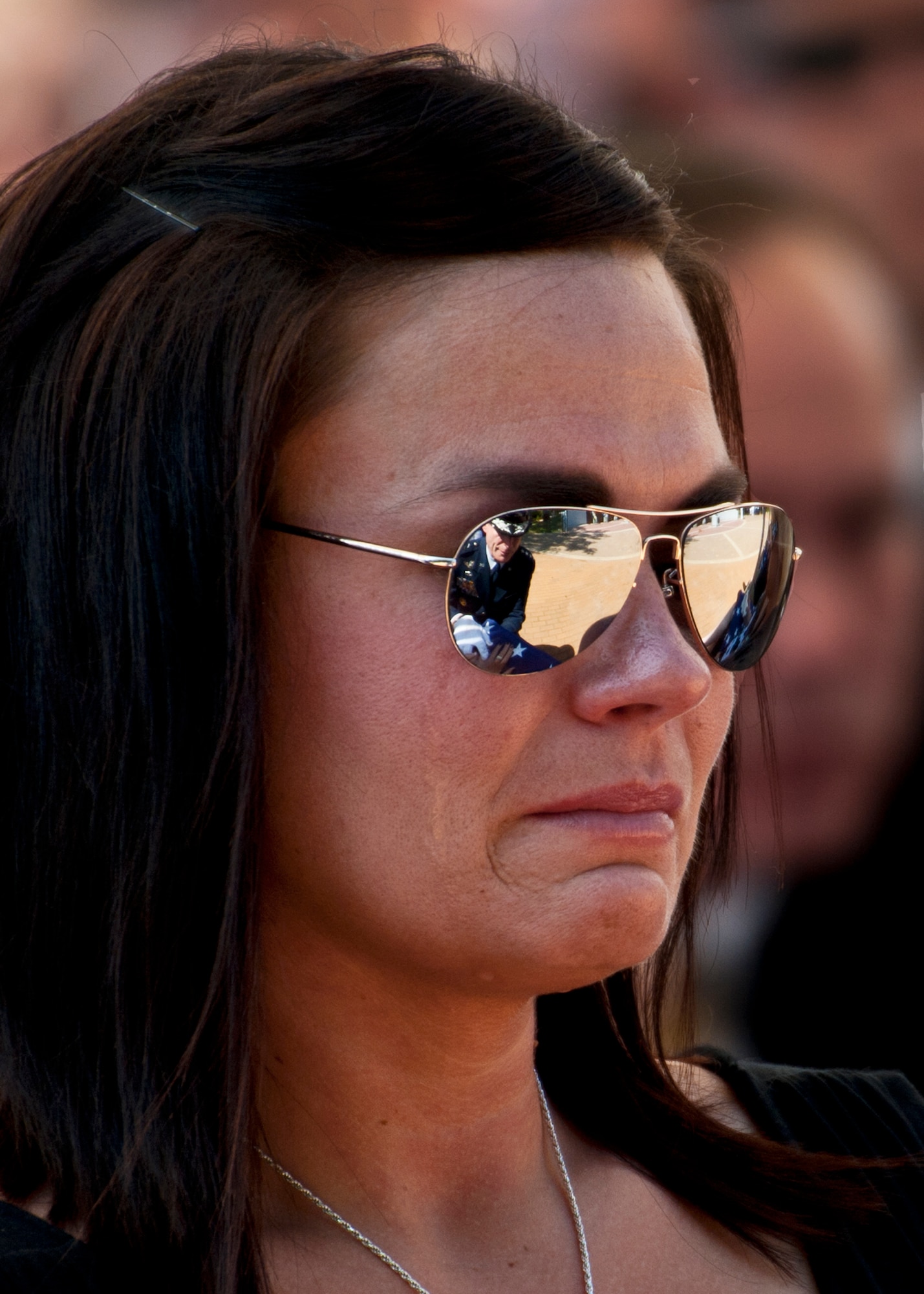 Kristen Johnson, widow of Senior Airman Daniel Johnson, tries to keep her composure after receiving a folded flag from Air Force Chief of Staff Gen. Norton Schwartz during the Explosive Ordnance Disposal Memorial ceremony May 7, 2011, at Eglin Air Force Base, Fla.  General Schwartz also presented a flag to Senior Airman Michael Buras’ widow, Emily, at the ceremony.  Fifteen new names were added to the memorial wall this year.  The total, which includes all services, now stands at 269.  (U.S. Air Force photo/Samuel King Jr.)